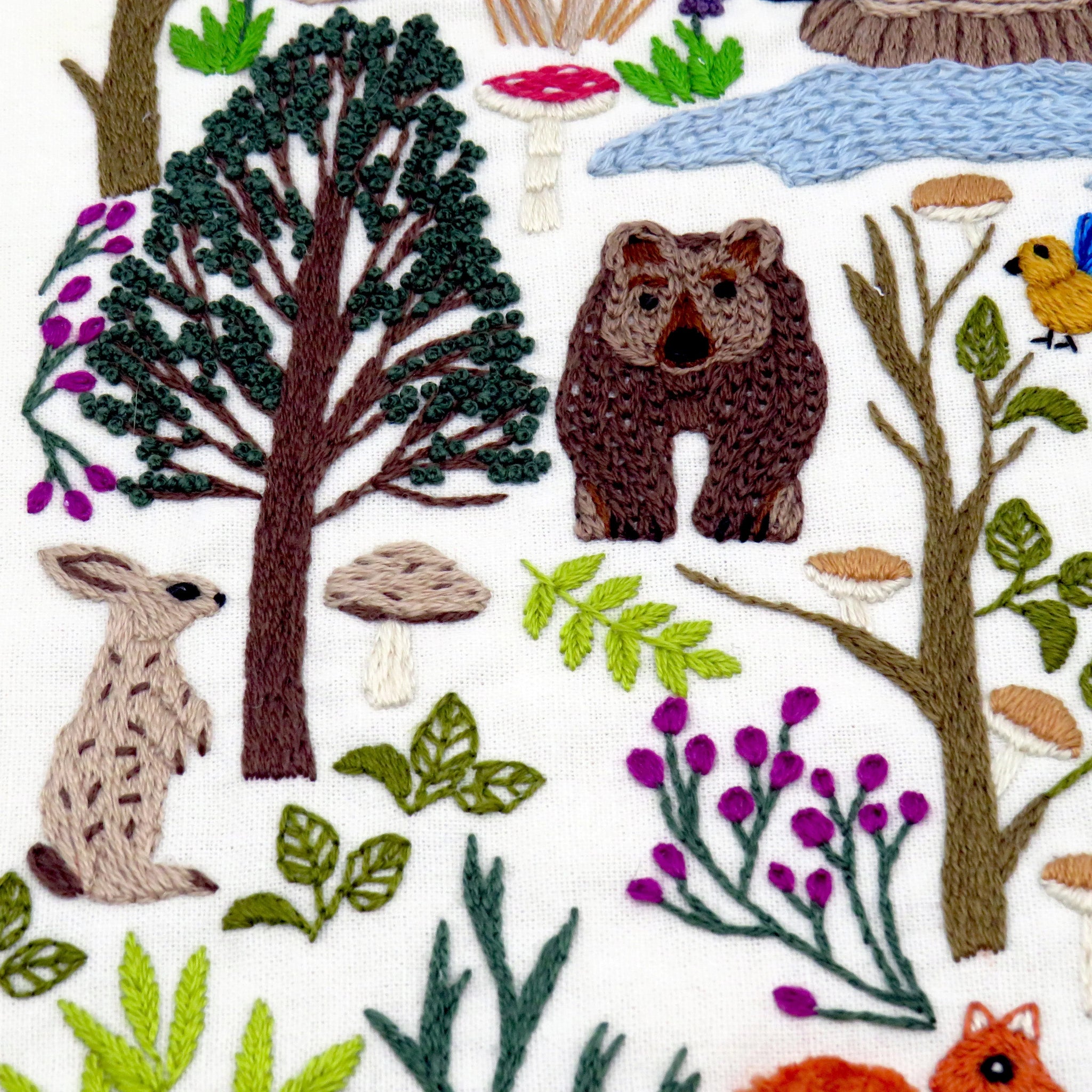 Embroidered pattern of forest animals and plants on a white background