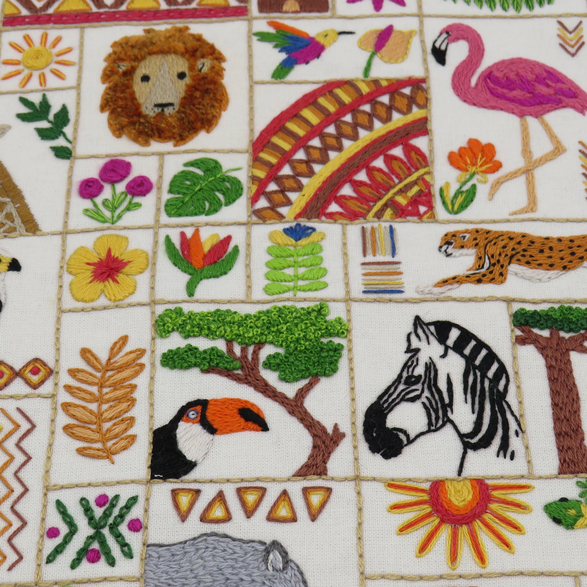 Embroidered pattern with animals, trees, and flowers on a white background