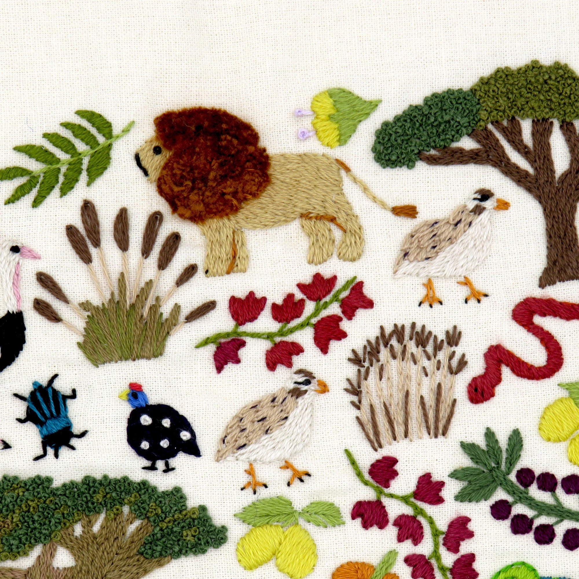 Embroidered pattern with animals, trees, and flowers on a white background