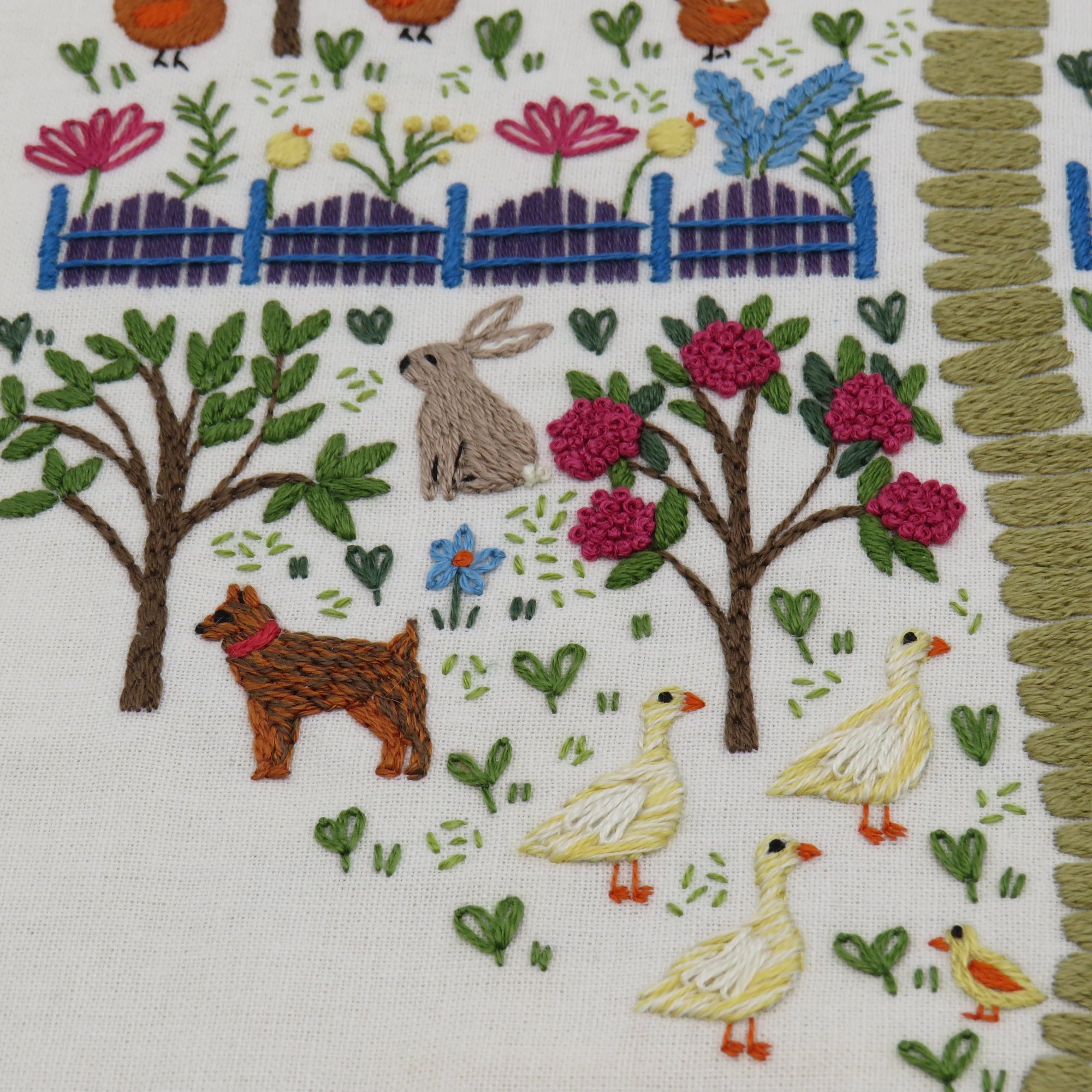 Embroidered scene with animals and plants on fabric