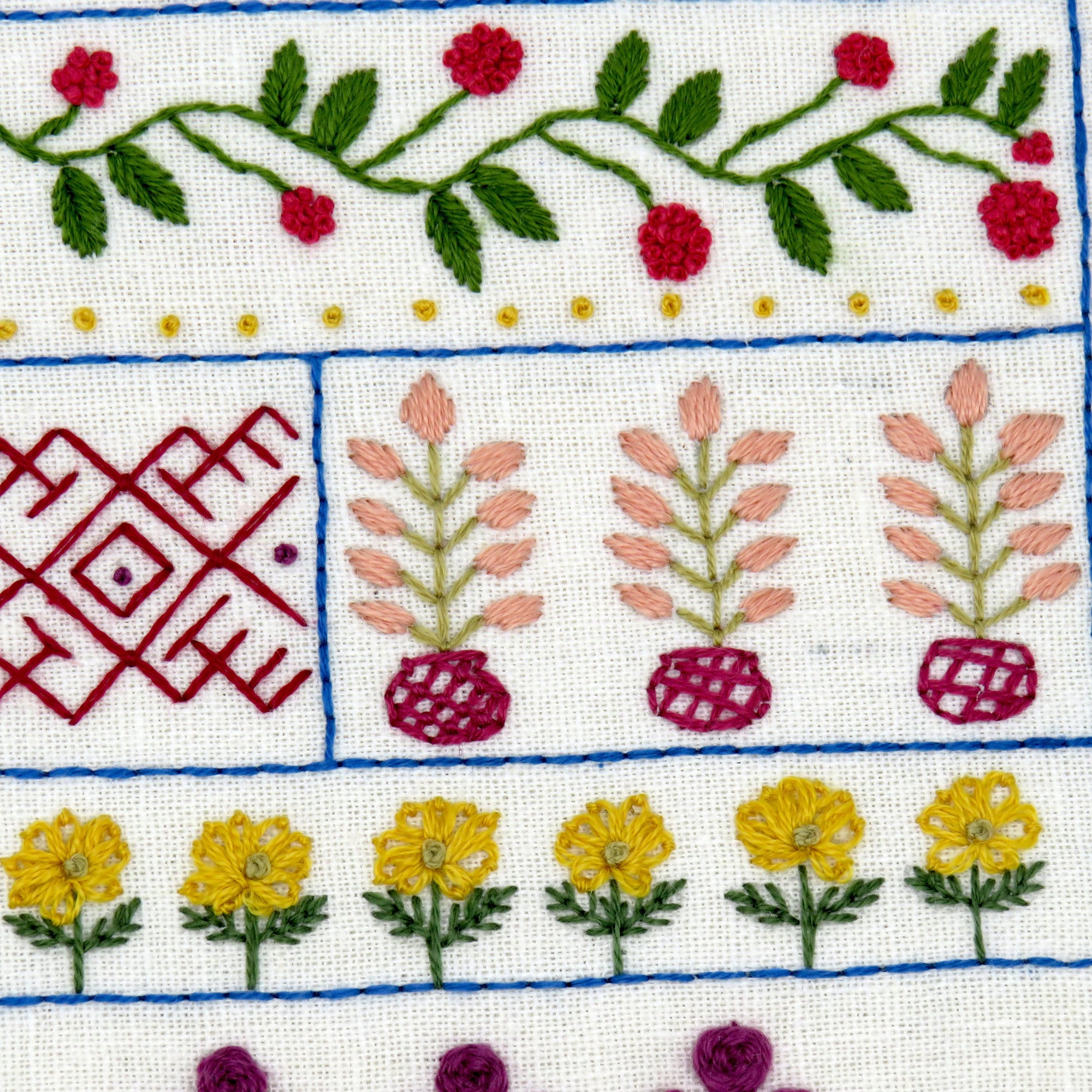 Embroidered fabric with floral and geometric patterns on a white background