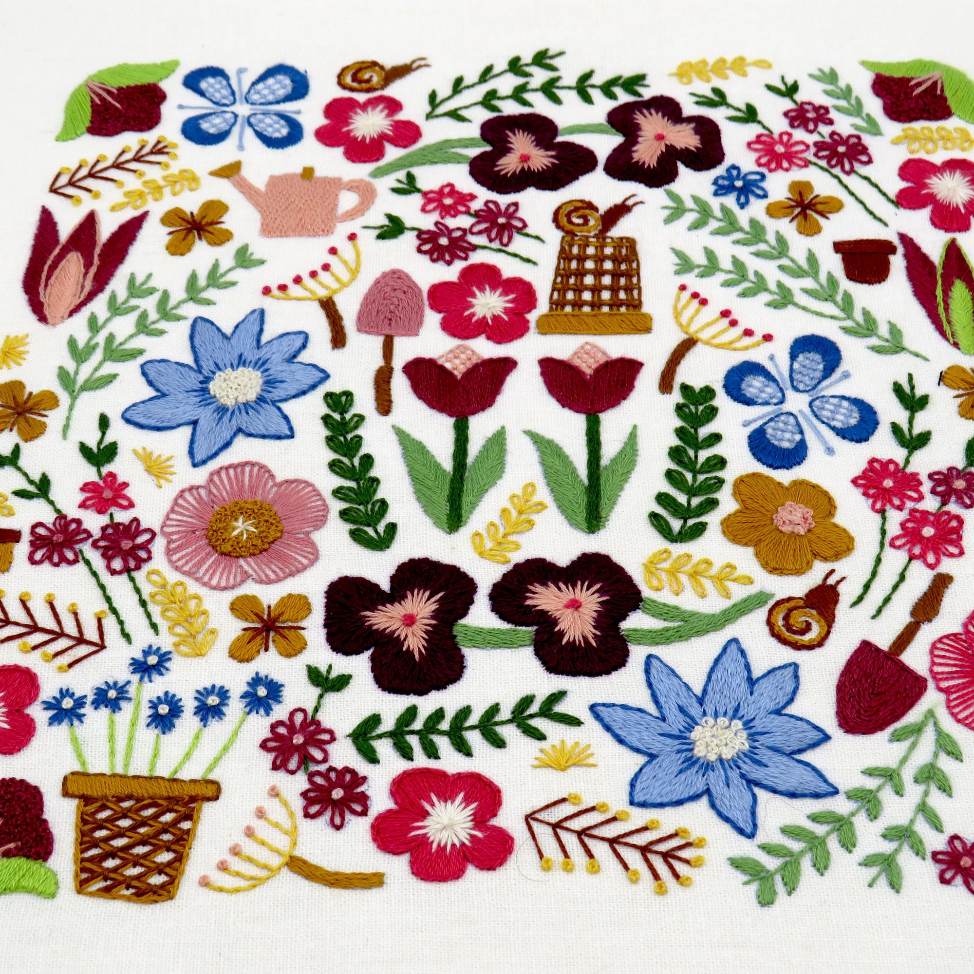 Embroidered design of flowers and plants on a white background