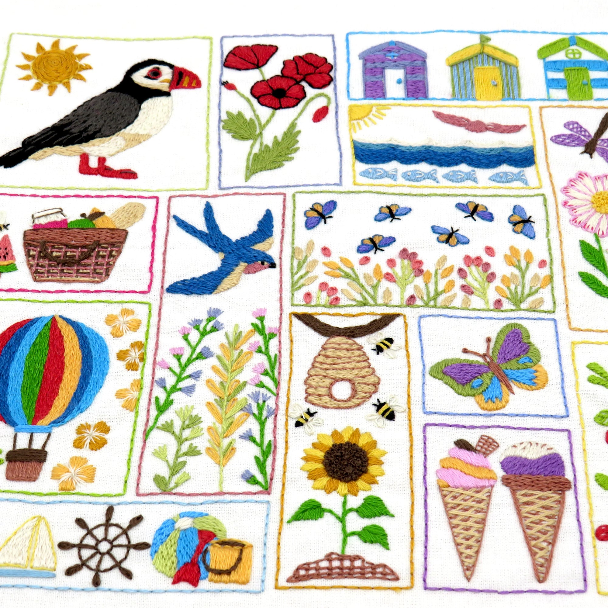 Collection of embroidered patches with various designs including a puffin, flowers, houses, and ice cream cones.