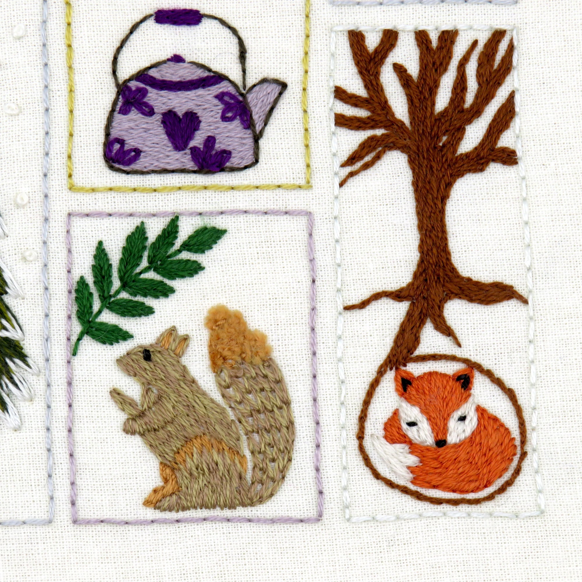 Embroidered patches featuring a teapot, tree, squirrel, and fox on a white background.