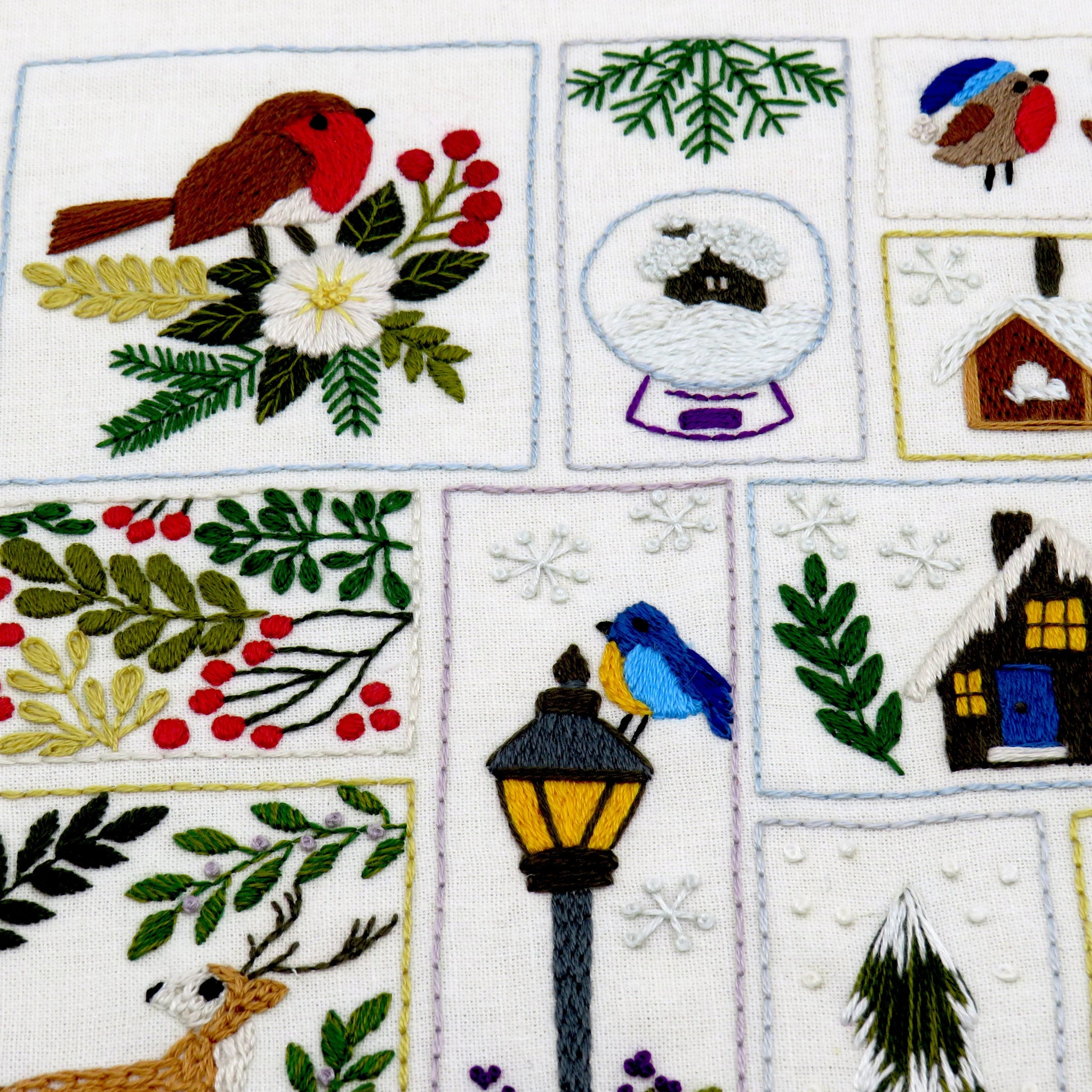 Embroidered patchwork design with winter-themed elements on a white background