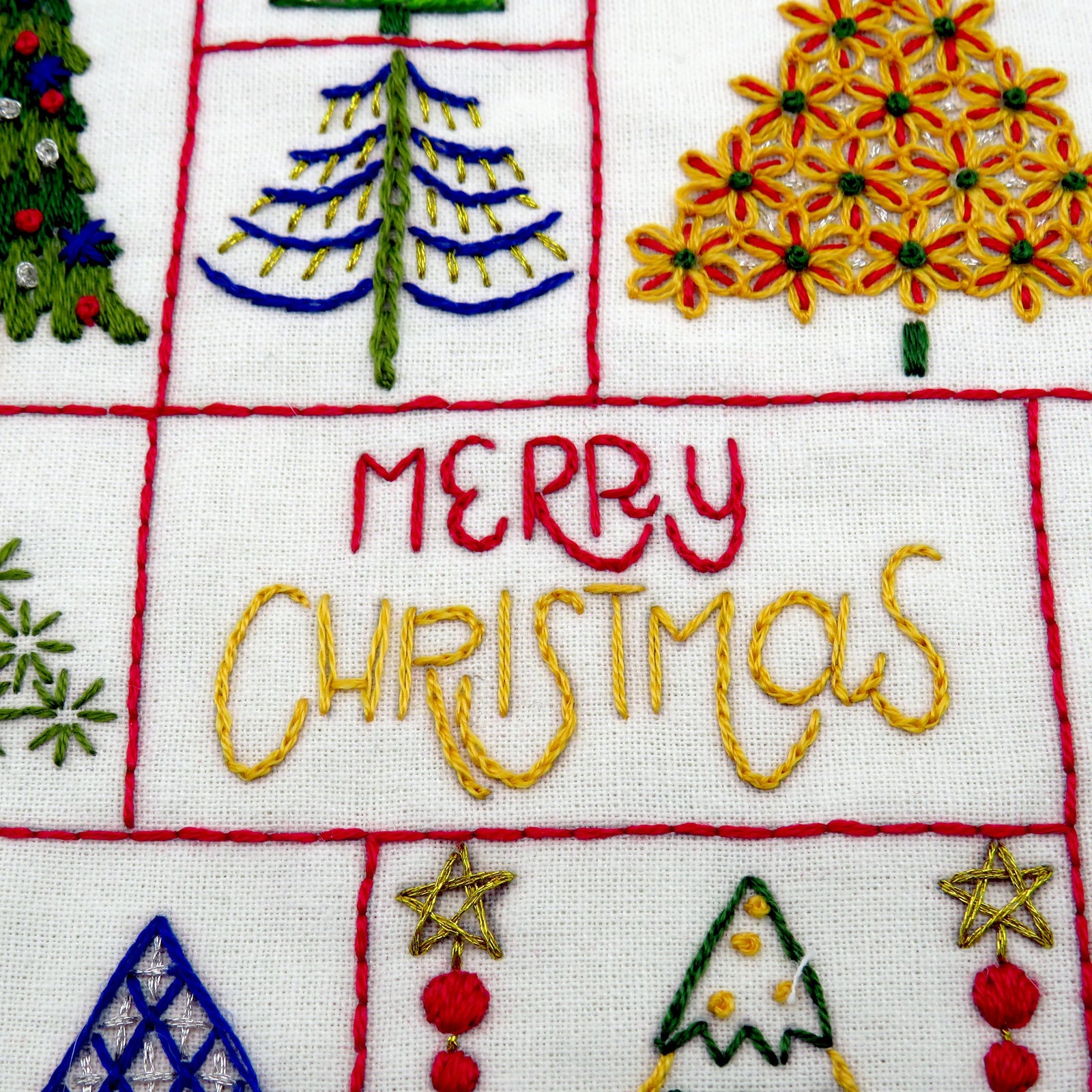 Embroidered fabric with Christmas-themed designs and 'Merry Christmassy' text.