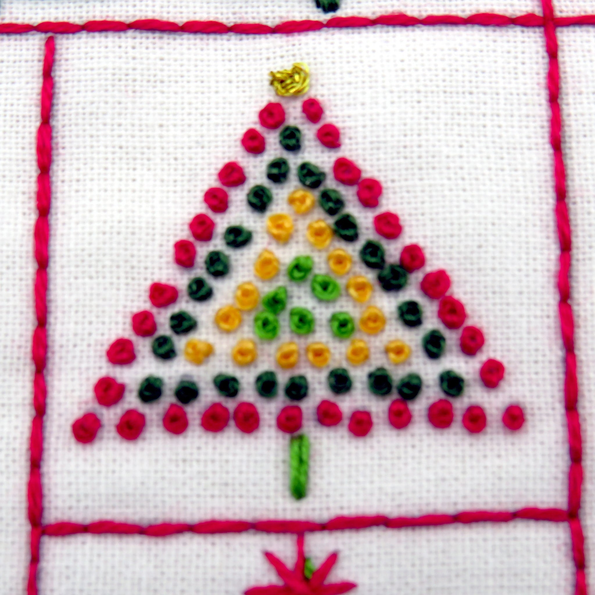 Embroidered Christmas tree design on fabric with red border
