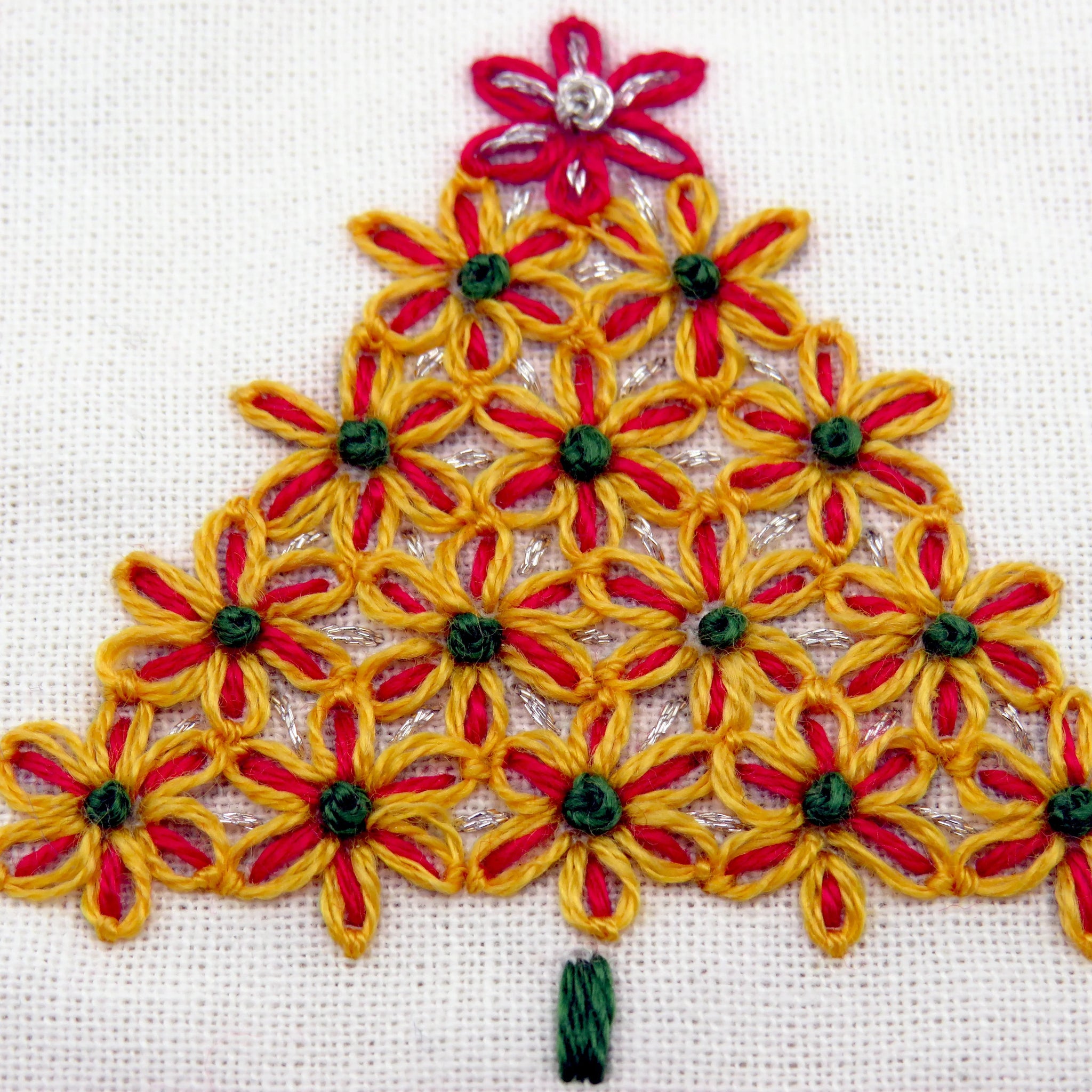 Embroidered Christmas tree design with red and yellow flowers on a white background