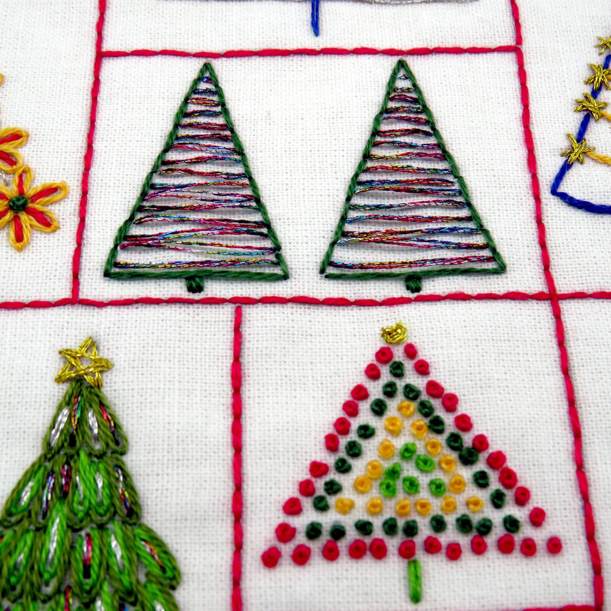 Embroidered Christmas trees on fabric with a white background