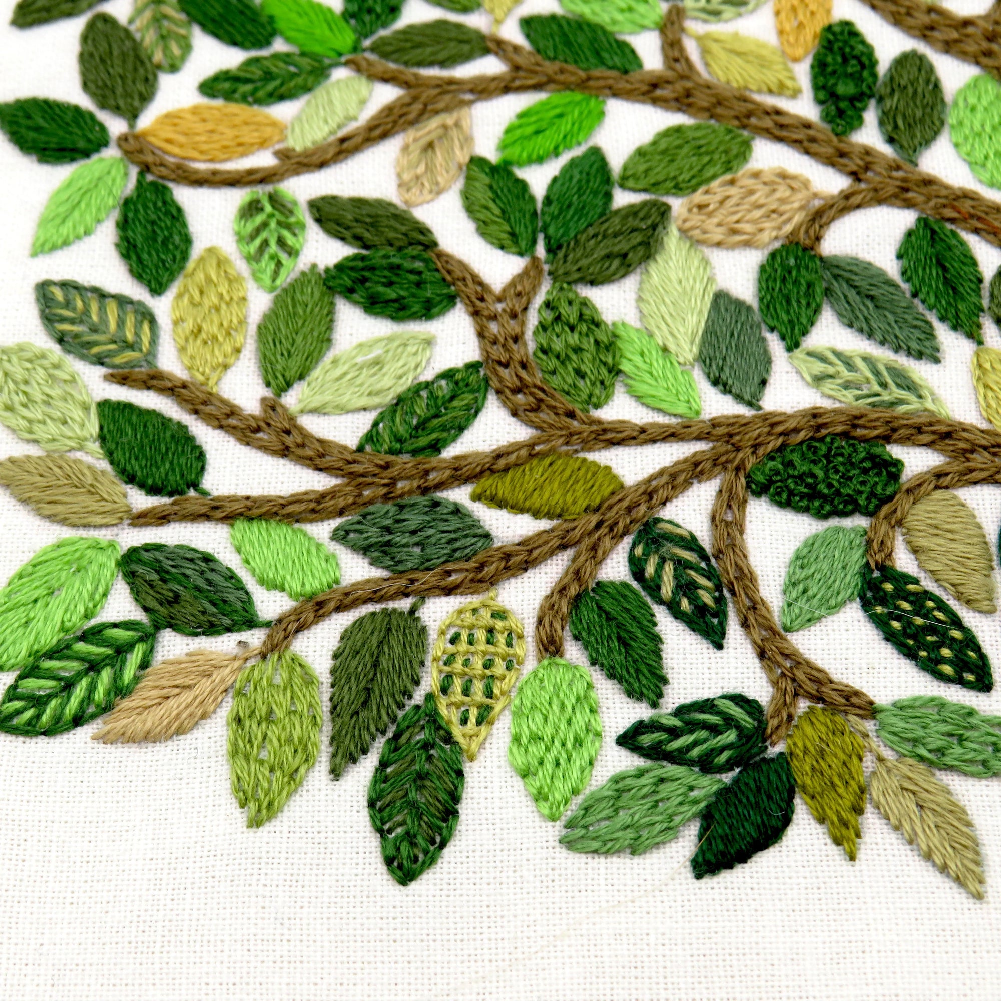 Embroidered design of leaves and branches on fabric