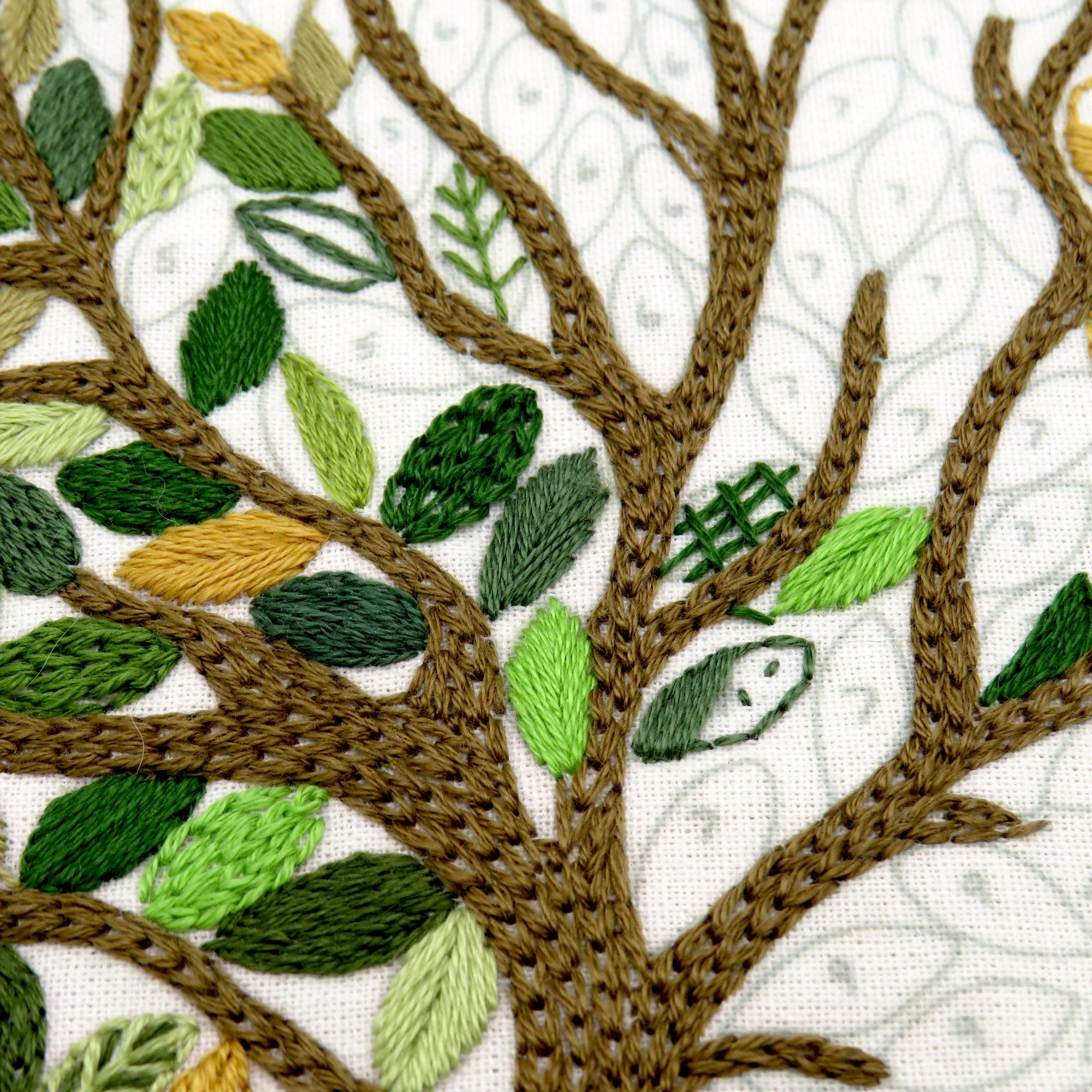 Embroidered tree with green leaves on a white background