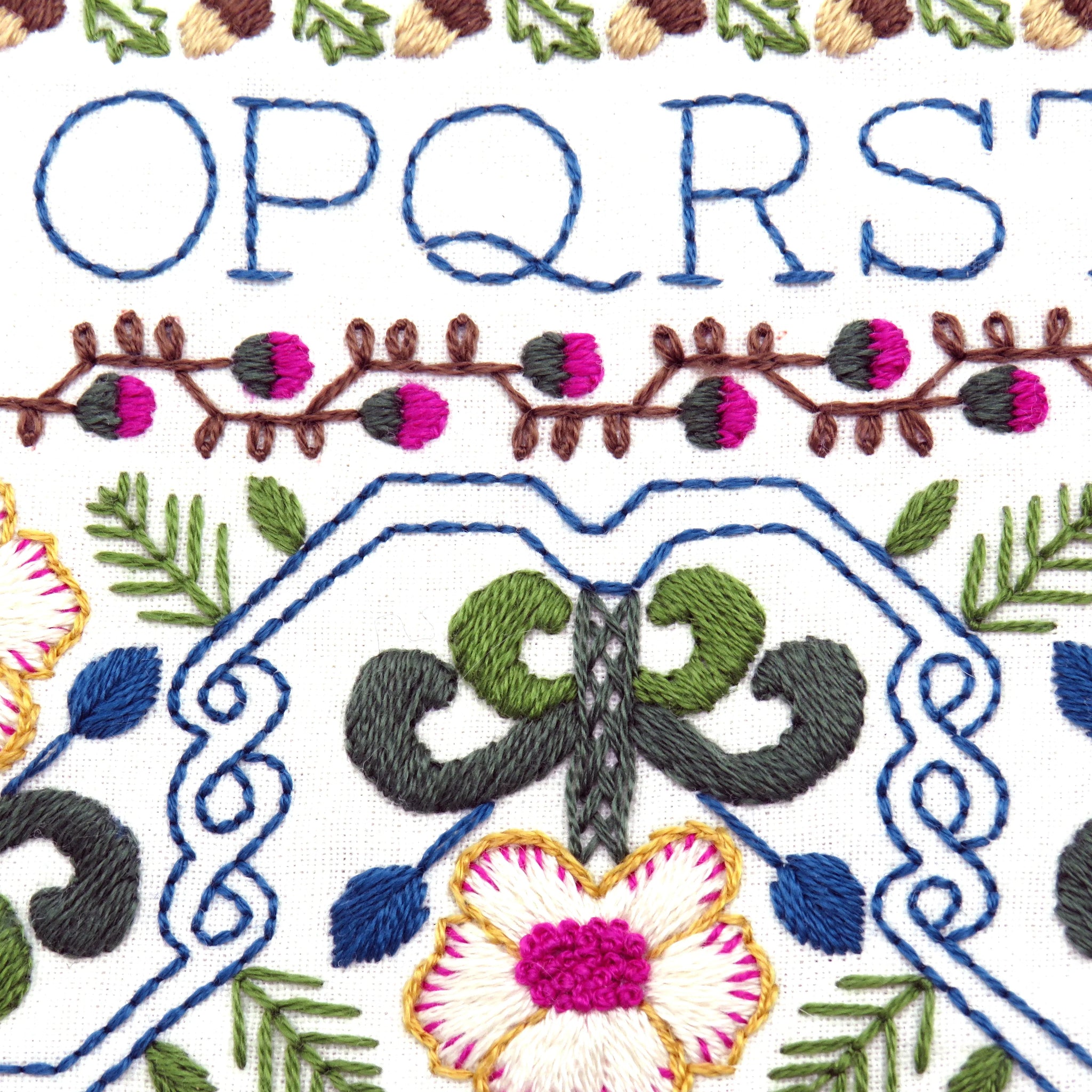 Embroidery pattern with floral and leaf designs on a white background