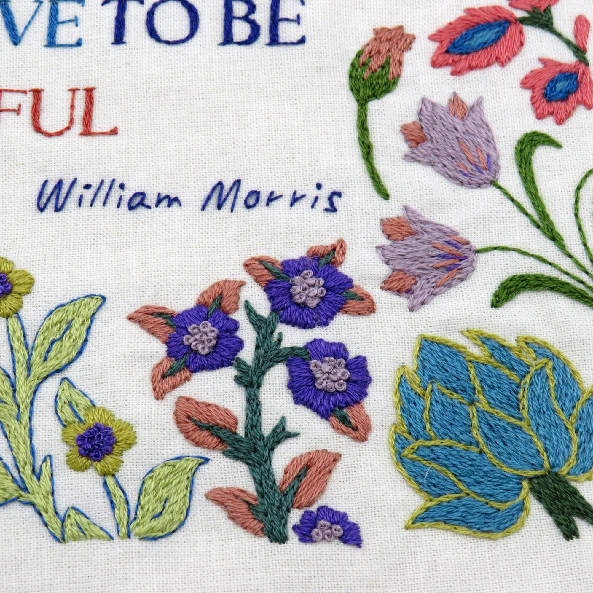 Embroidered text and floral patterns with 'Live to be' and 'William Morris' on a white background.