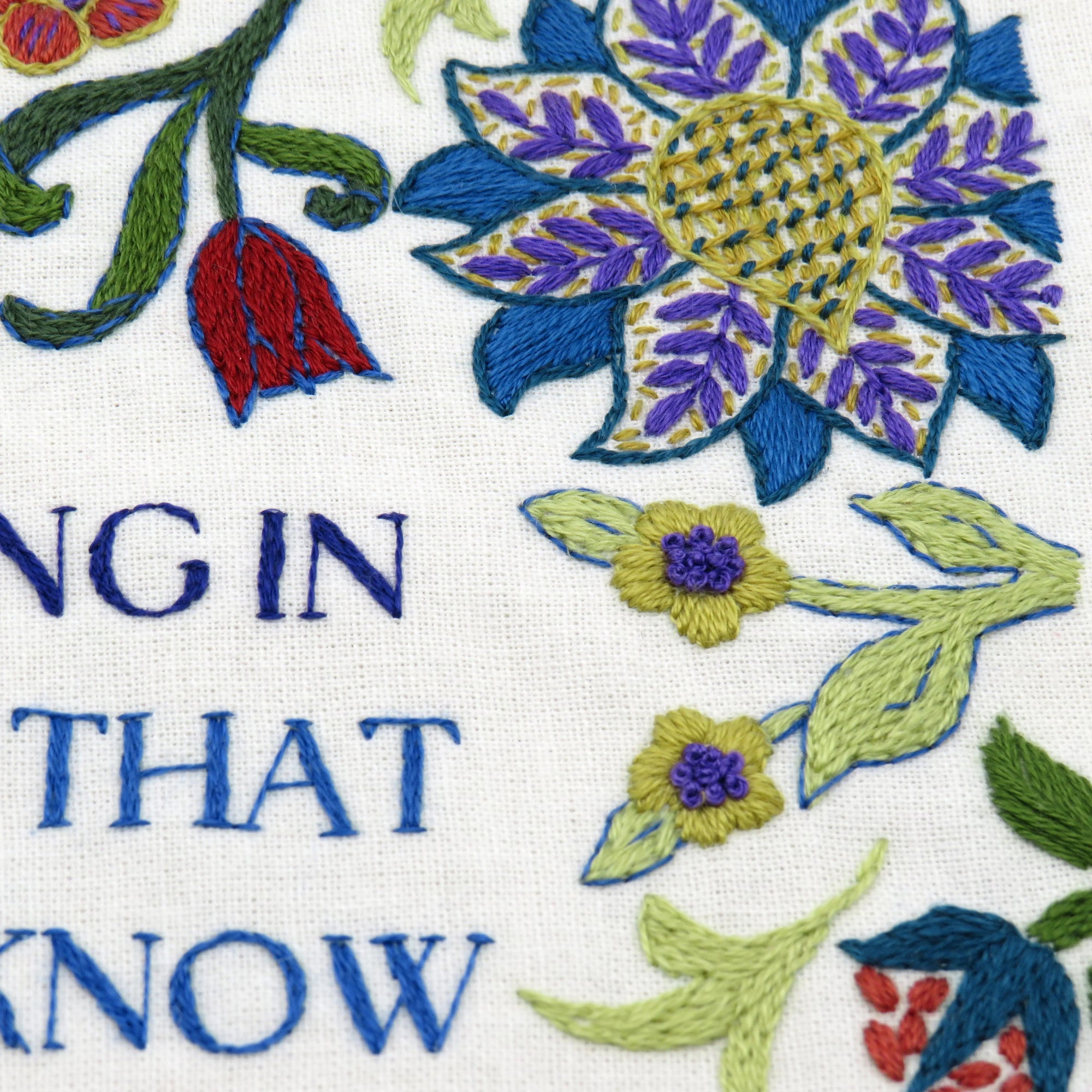 Embroidered floral design with text on a white background