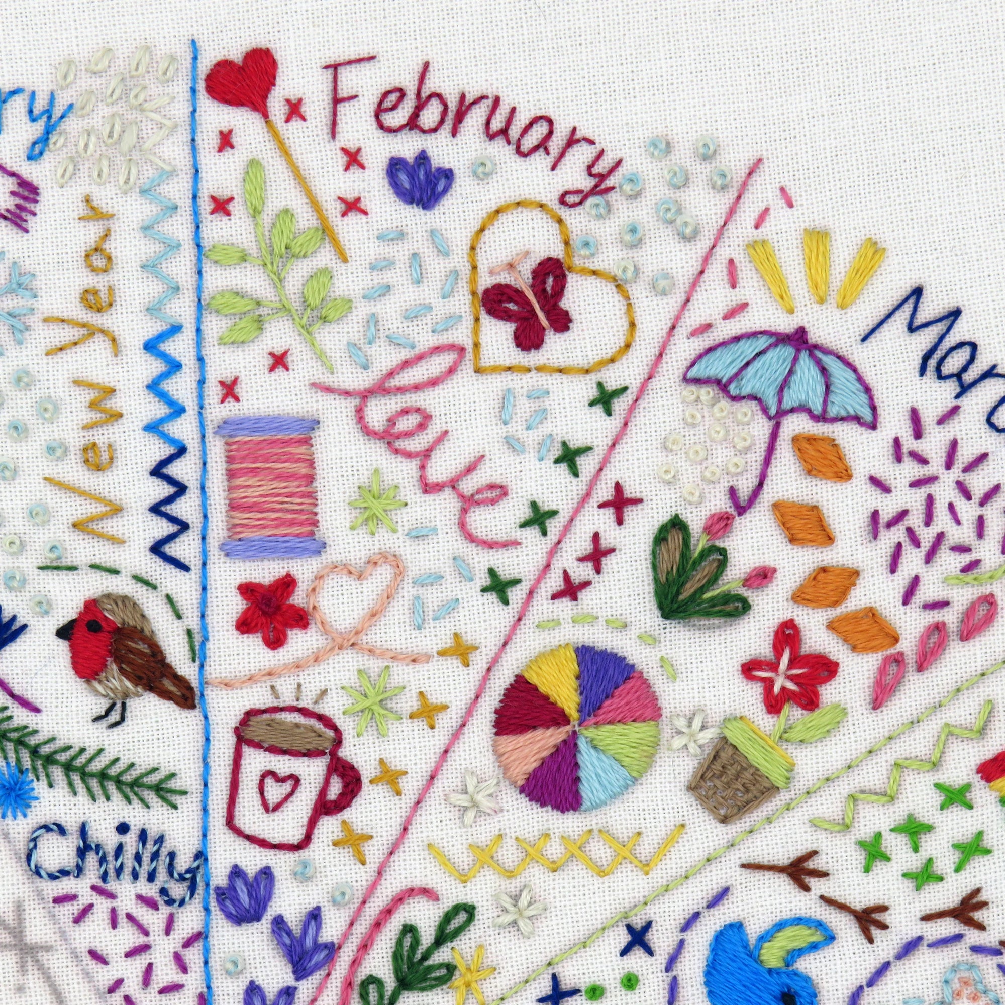 Embroidered design with months of the year and various decorative elements.