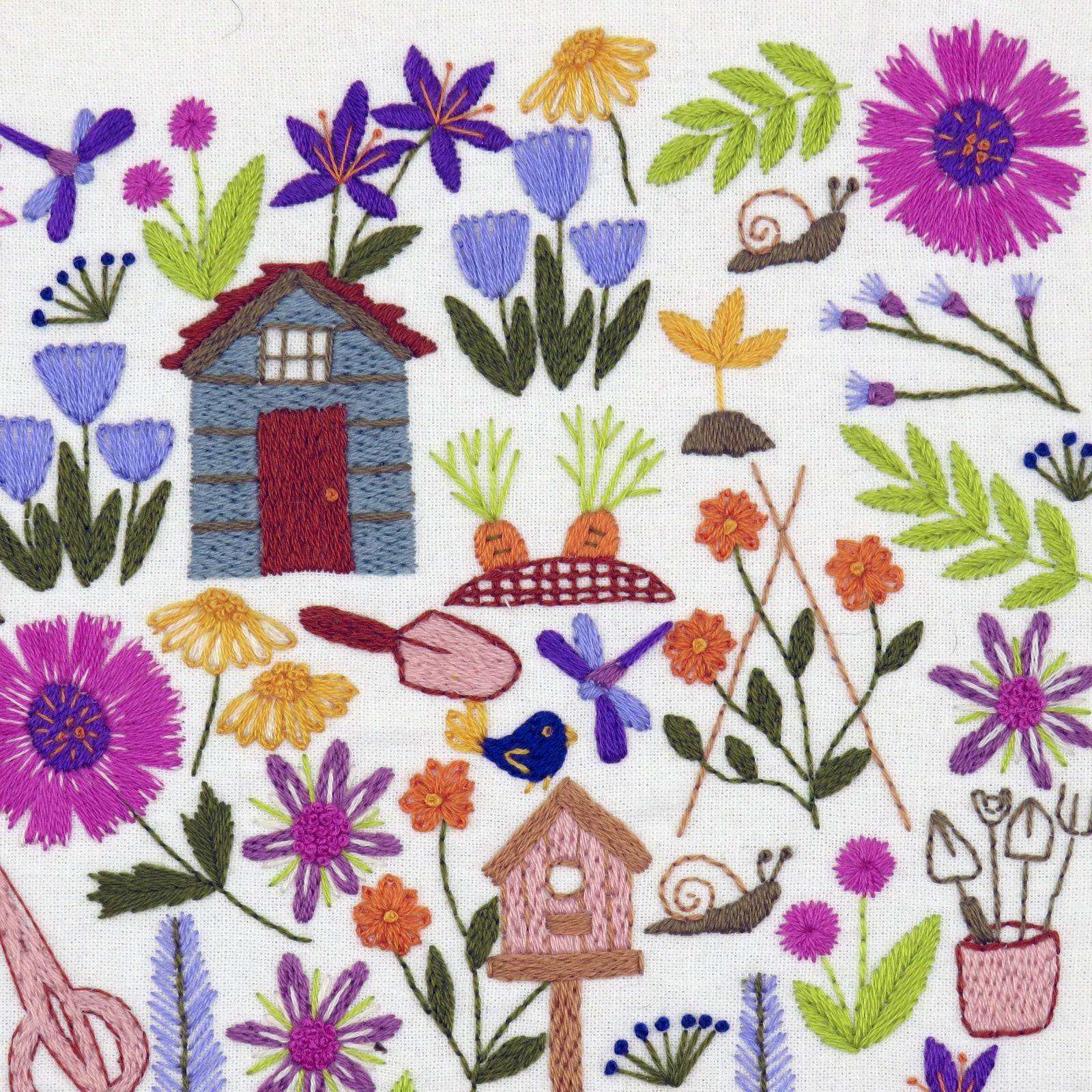 Embroidered design with flowers, a small house, and gardening tools on a white background.