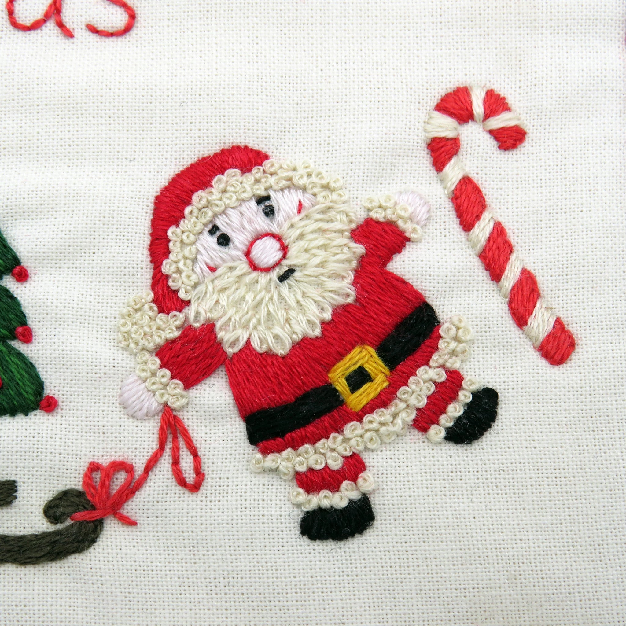 Embroidered Santa Claus figure with a candy cane on a white background