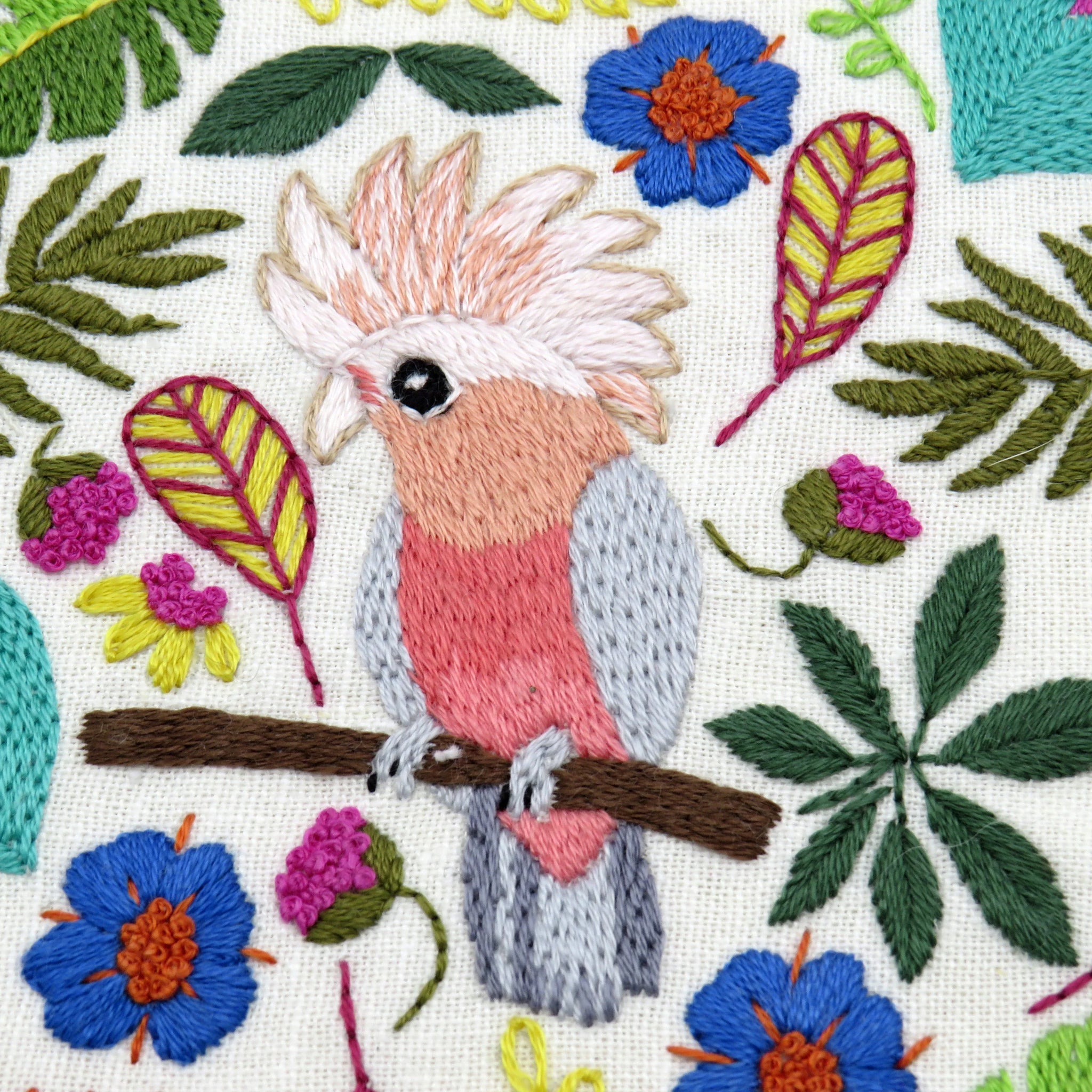 Embroidered parrot and floral pattern on fabric