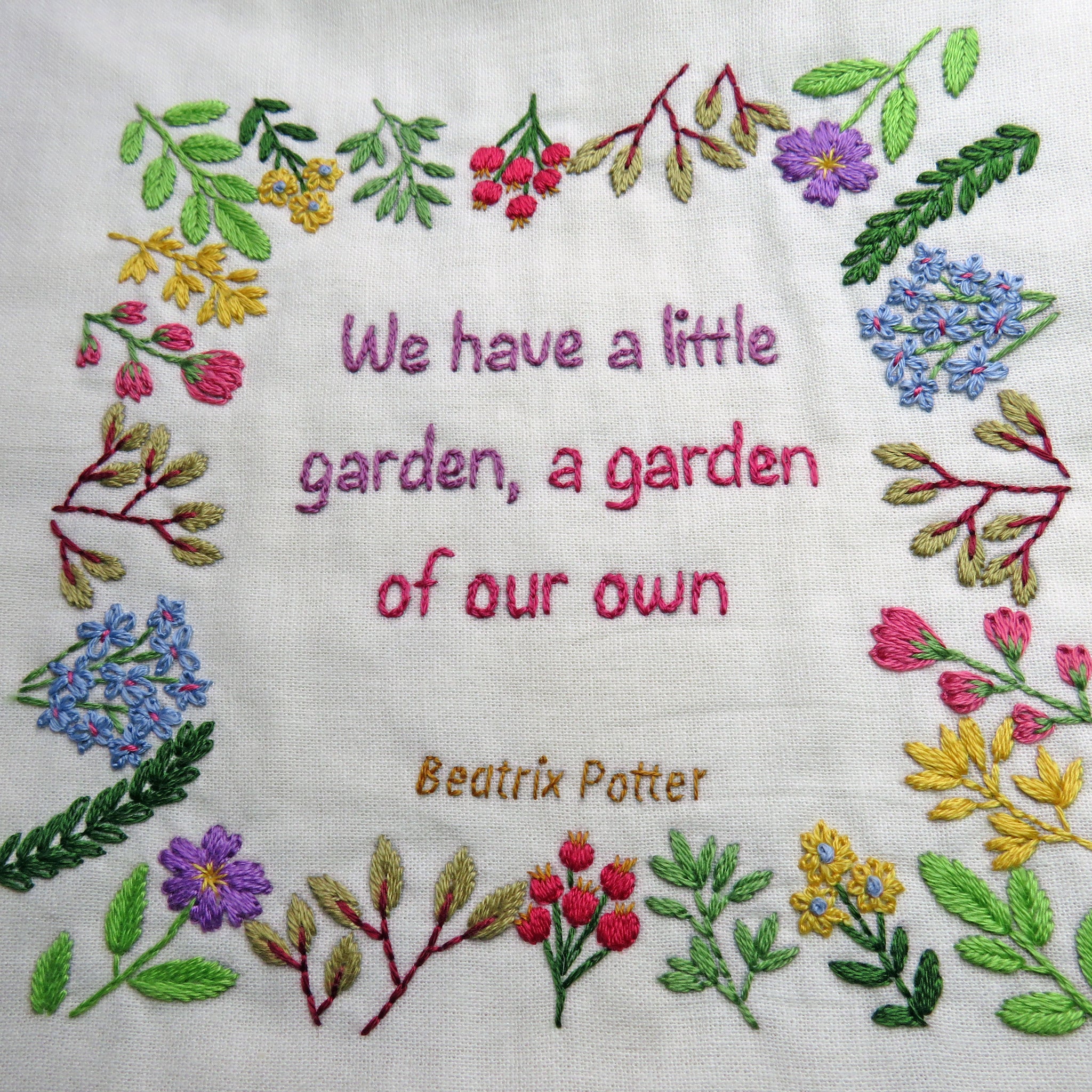 Embroidered text with floral border and Beatrix Potter quote on white fabric