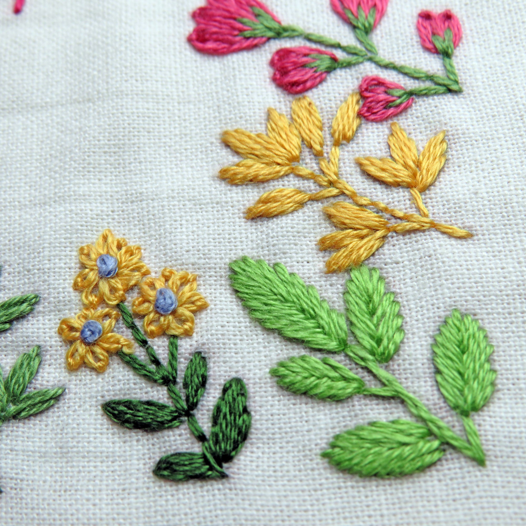Close-up of embroidered flowers and leaves on fabric