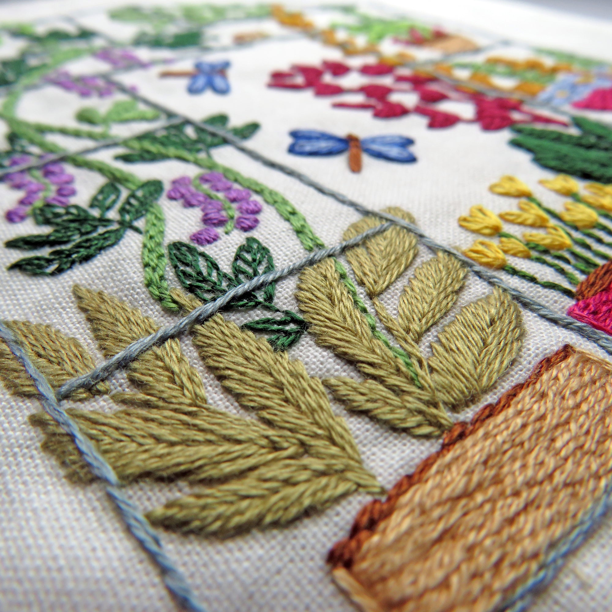 Close-up of an embroidered piece with flowers and leaves on fabric