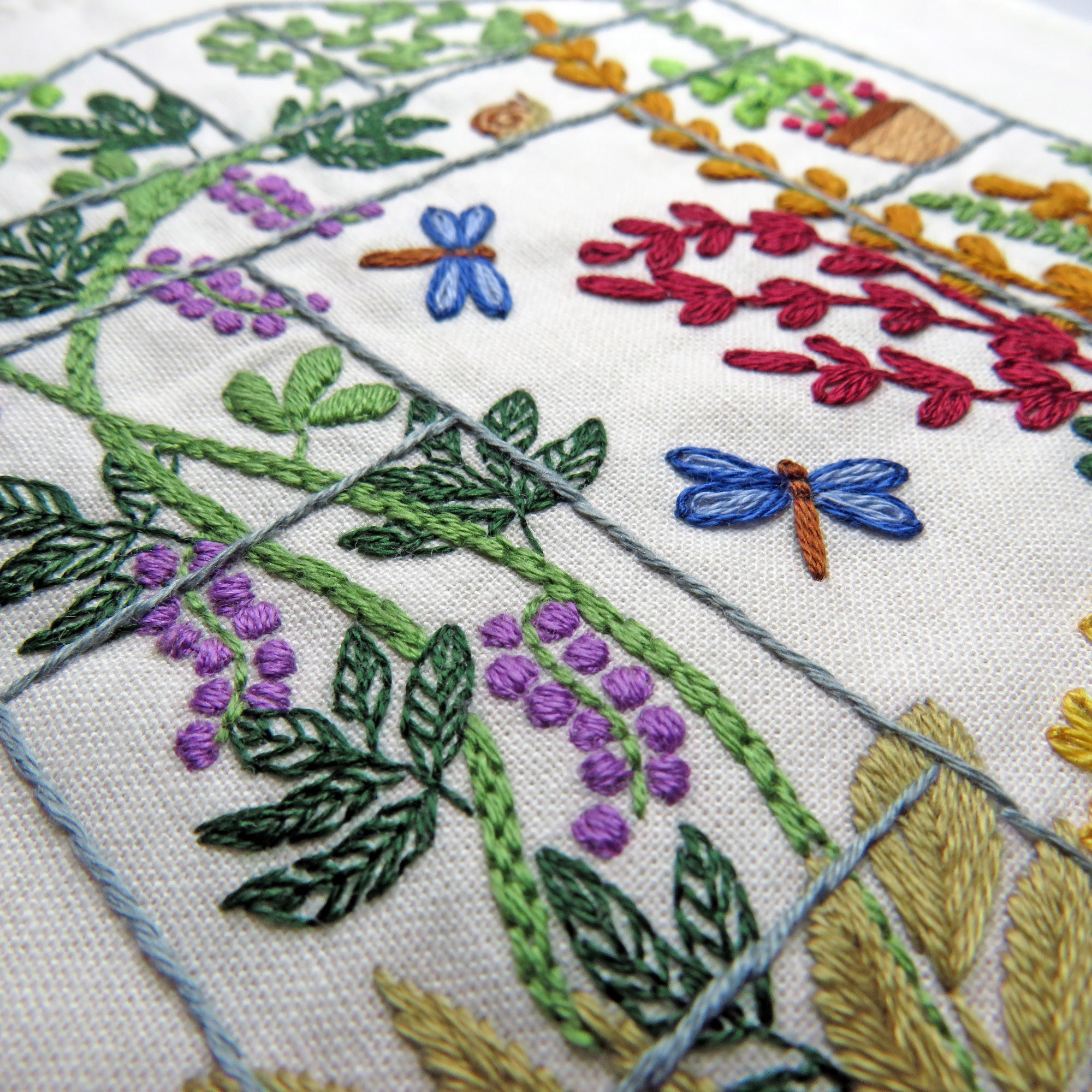 Embroidered fabric with floral and dragonfly patterns