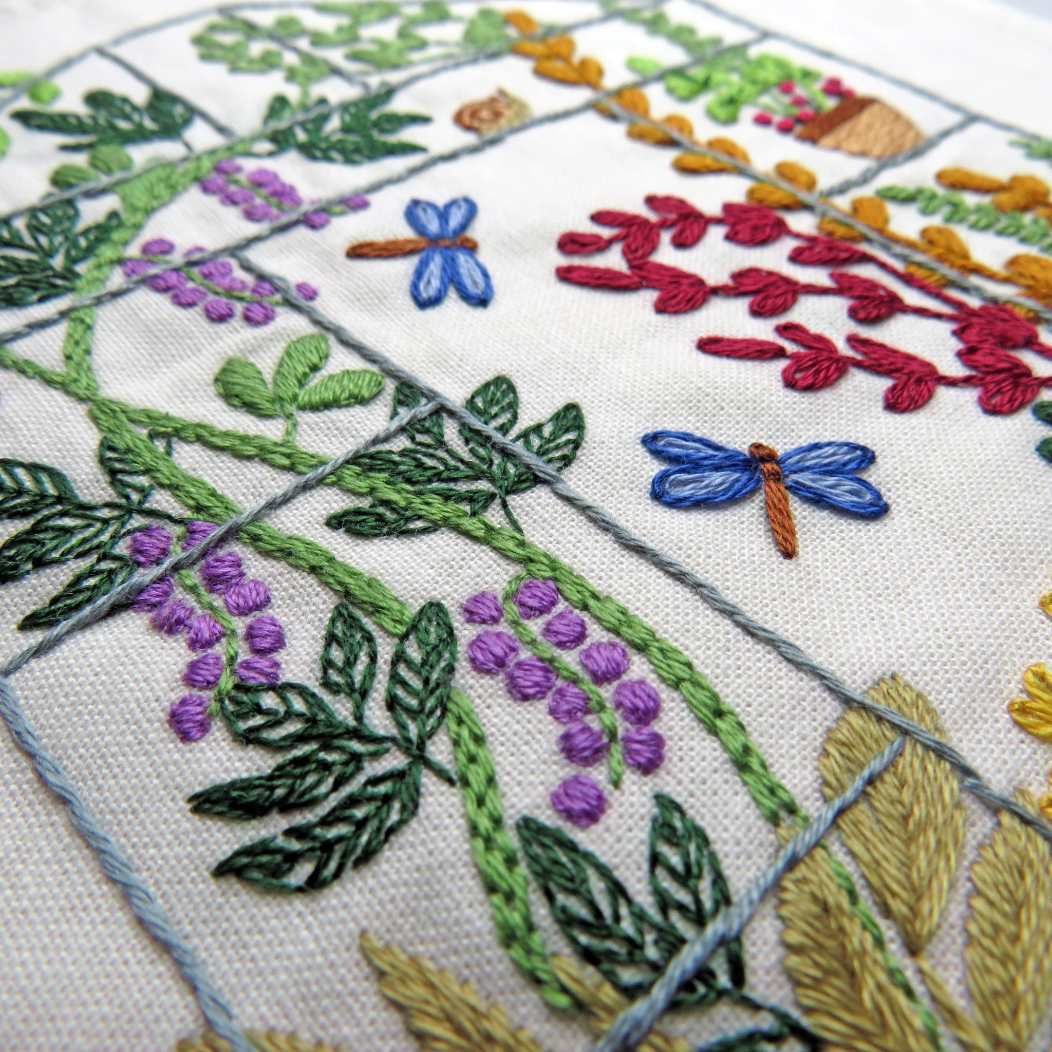 Embroidered fabric with floral and dragonfly patterns