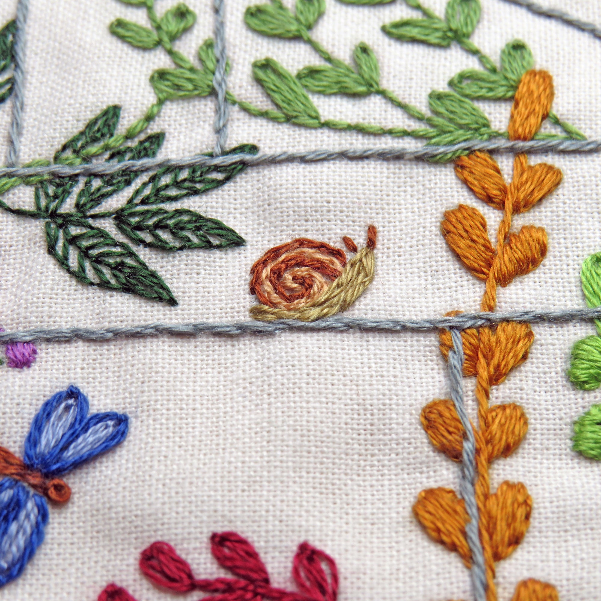 Close-up of embroidered floral and leaf patterns on fabric