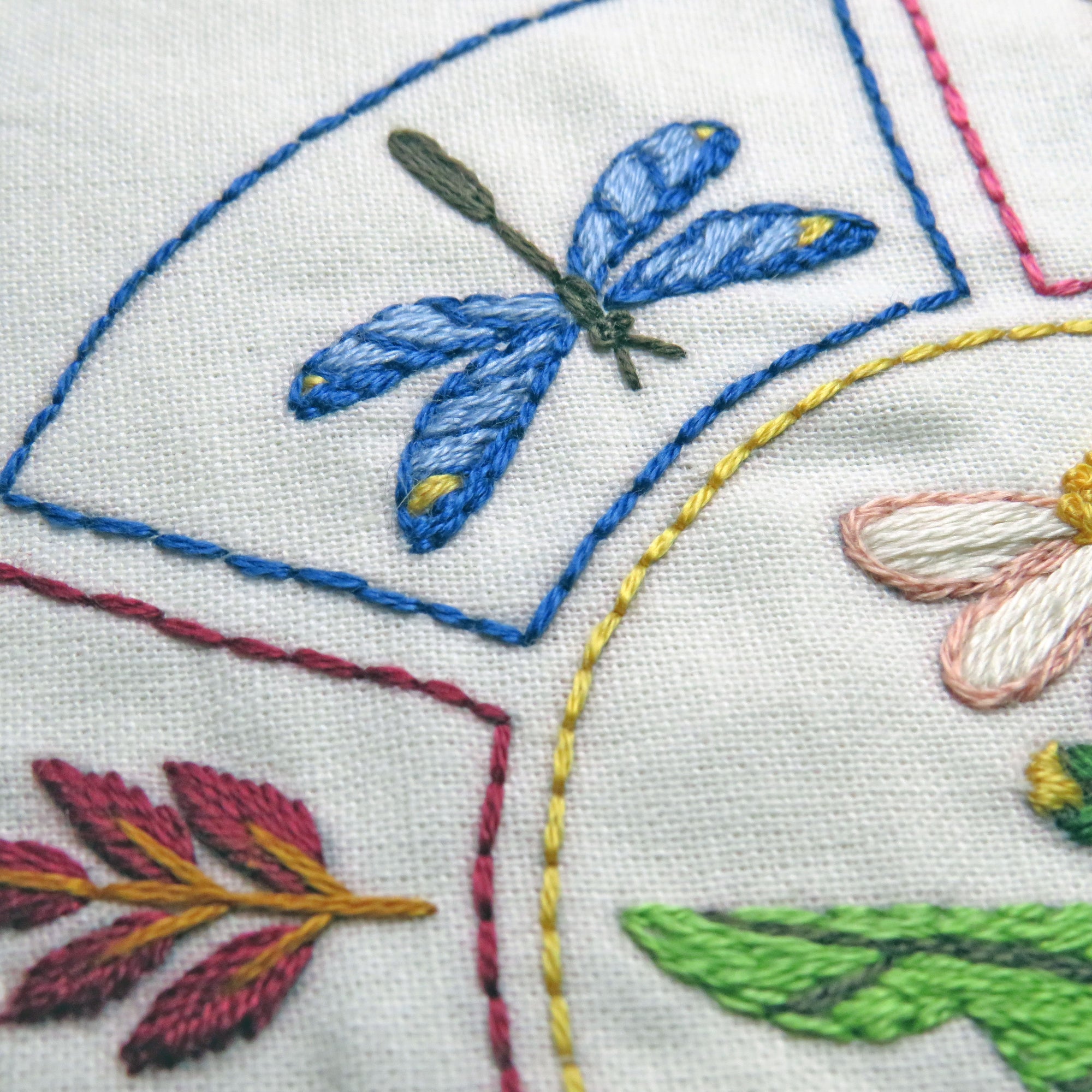 Close-up of embroidered fabric with floral and leaf patterns.