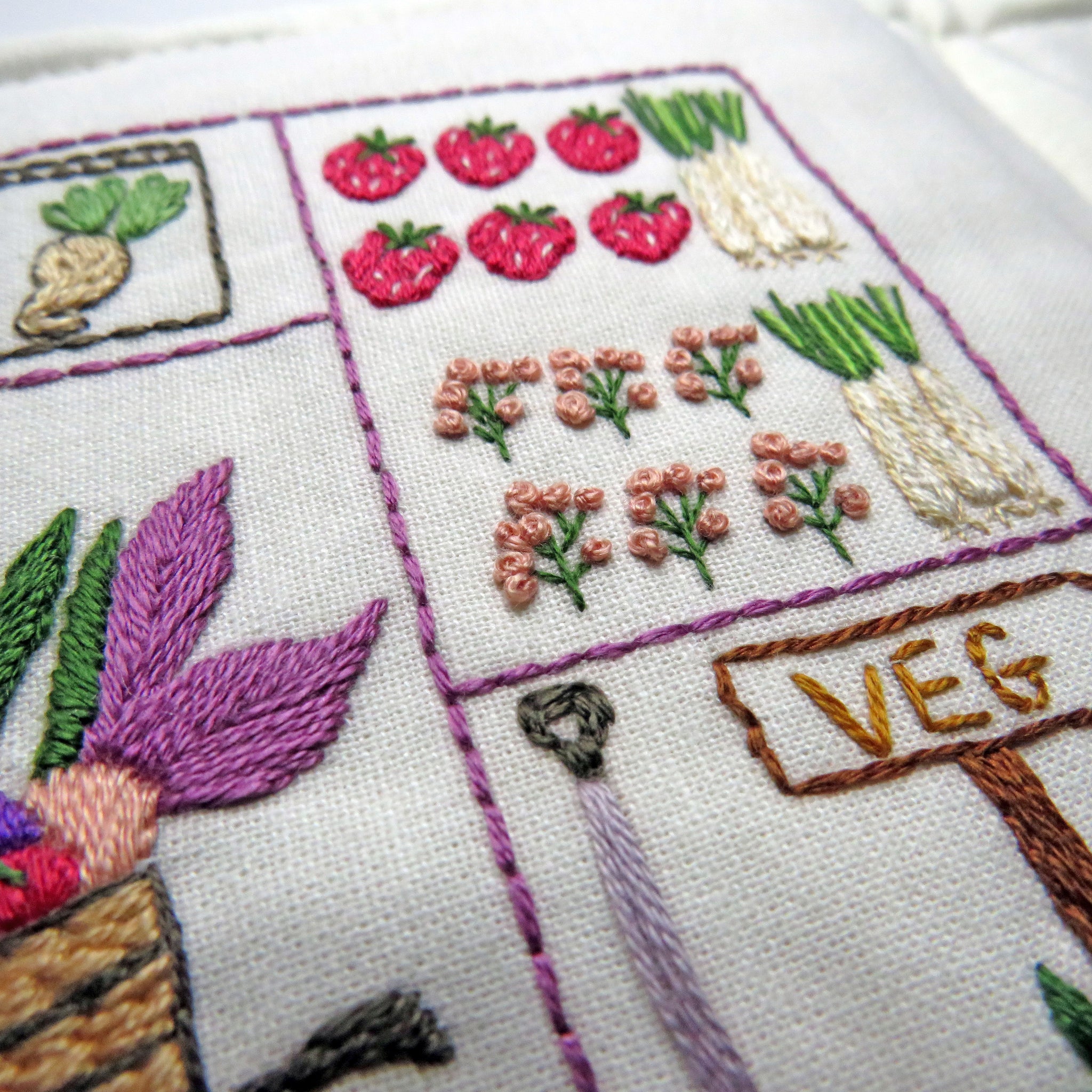 Embroidery design with vegetables and flowers on a white background