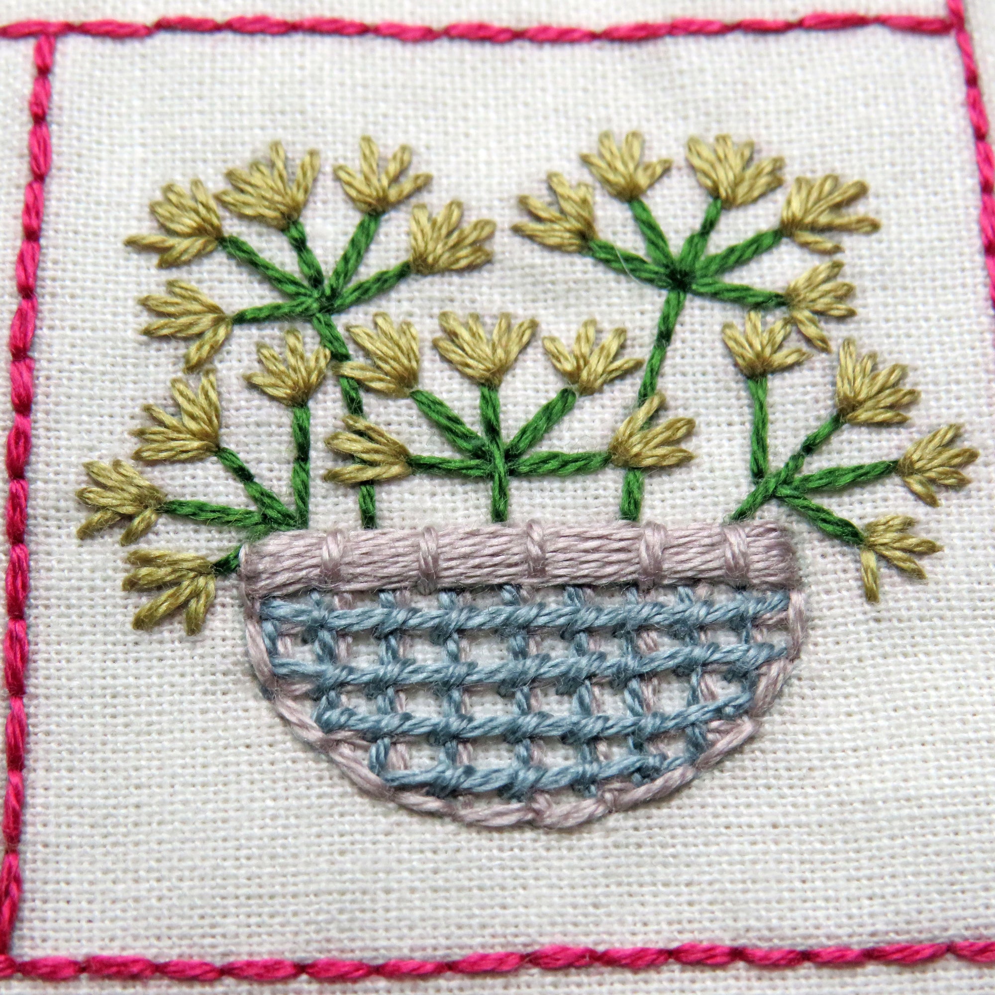 Embroidery of flowers in a basket with pink border