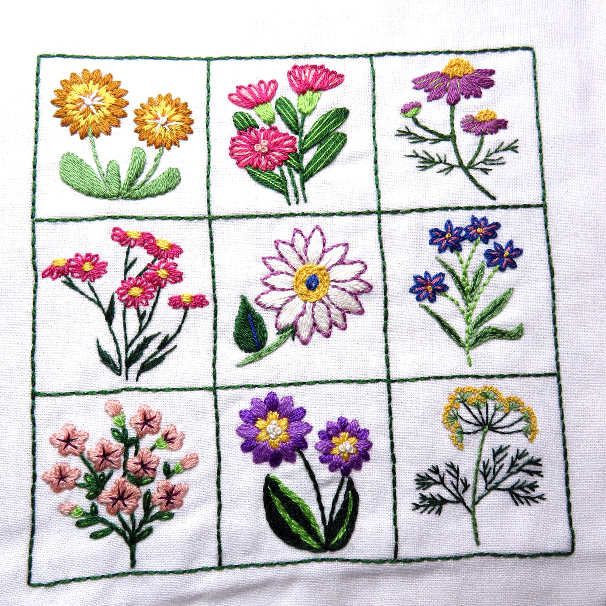 Embroidered patchwork of various flowers on a white background