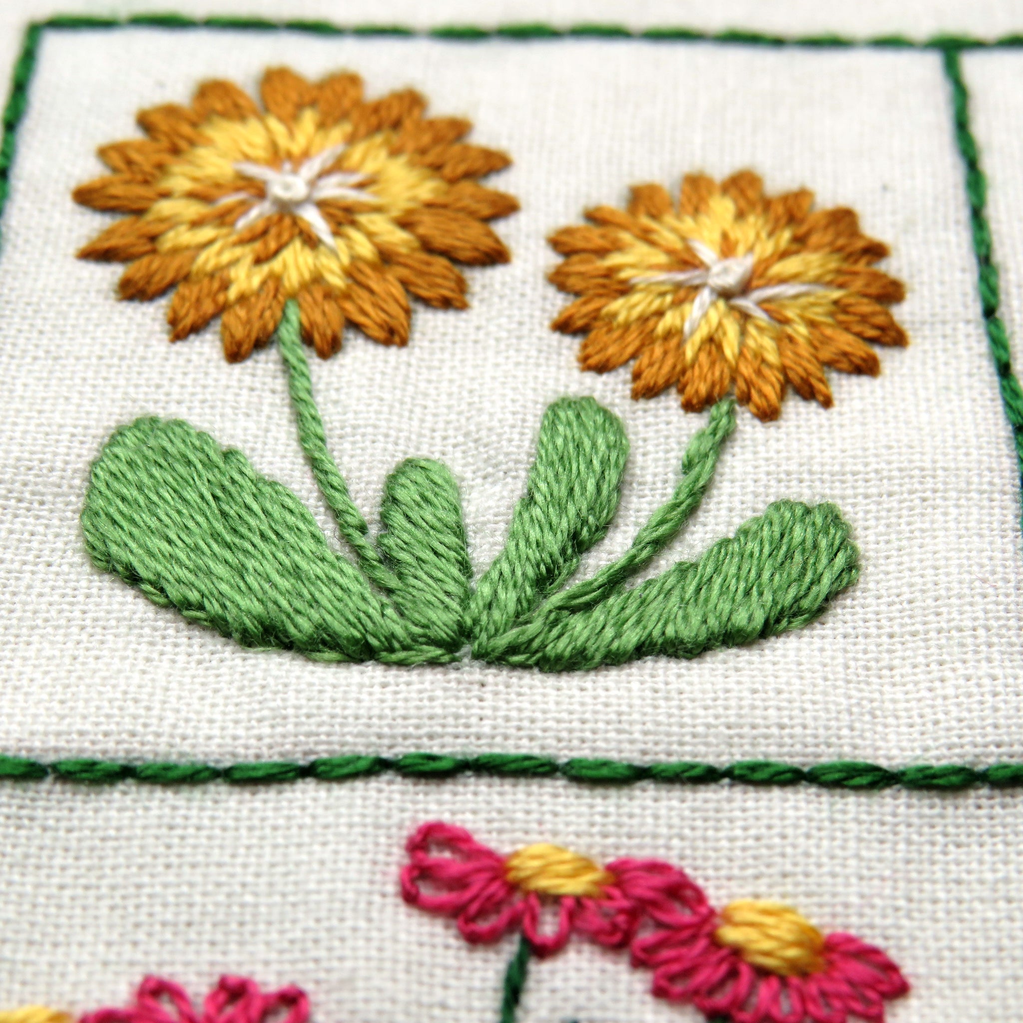 Embroidered flowers on fabric with green border