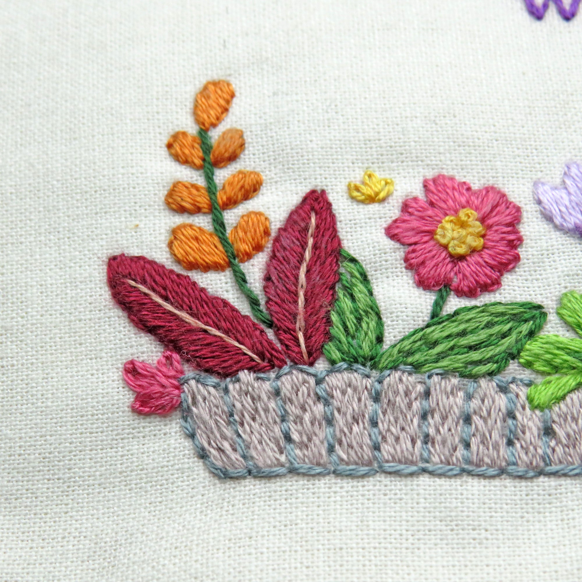 Embroidered design of flowers and leaves on fabric