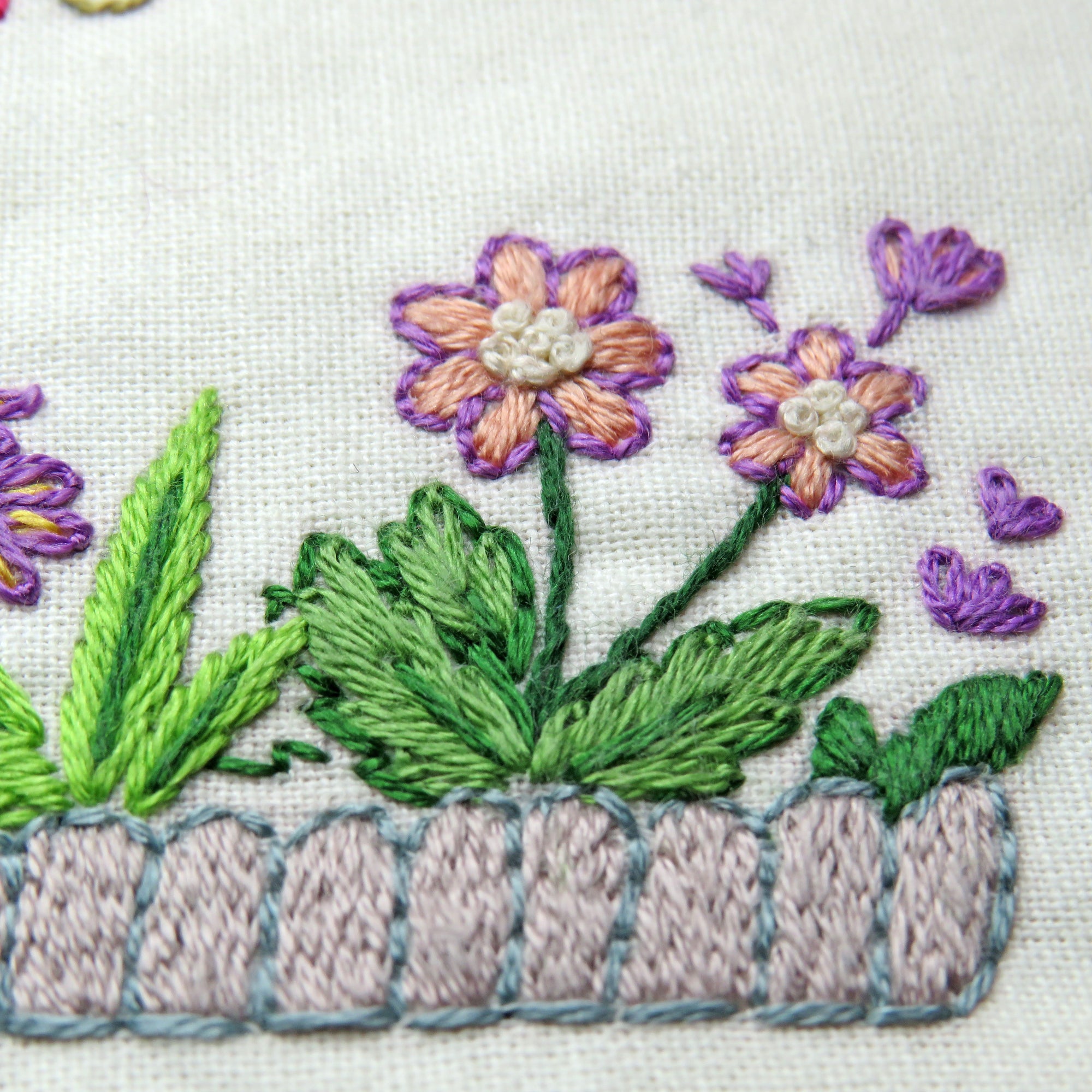 Embroidered design of flowers and leaves on fabric