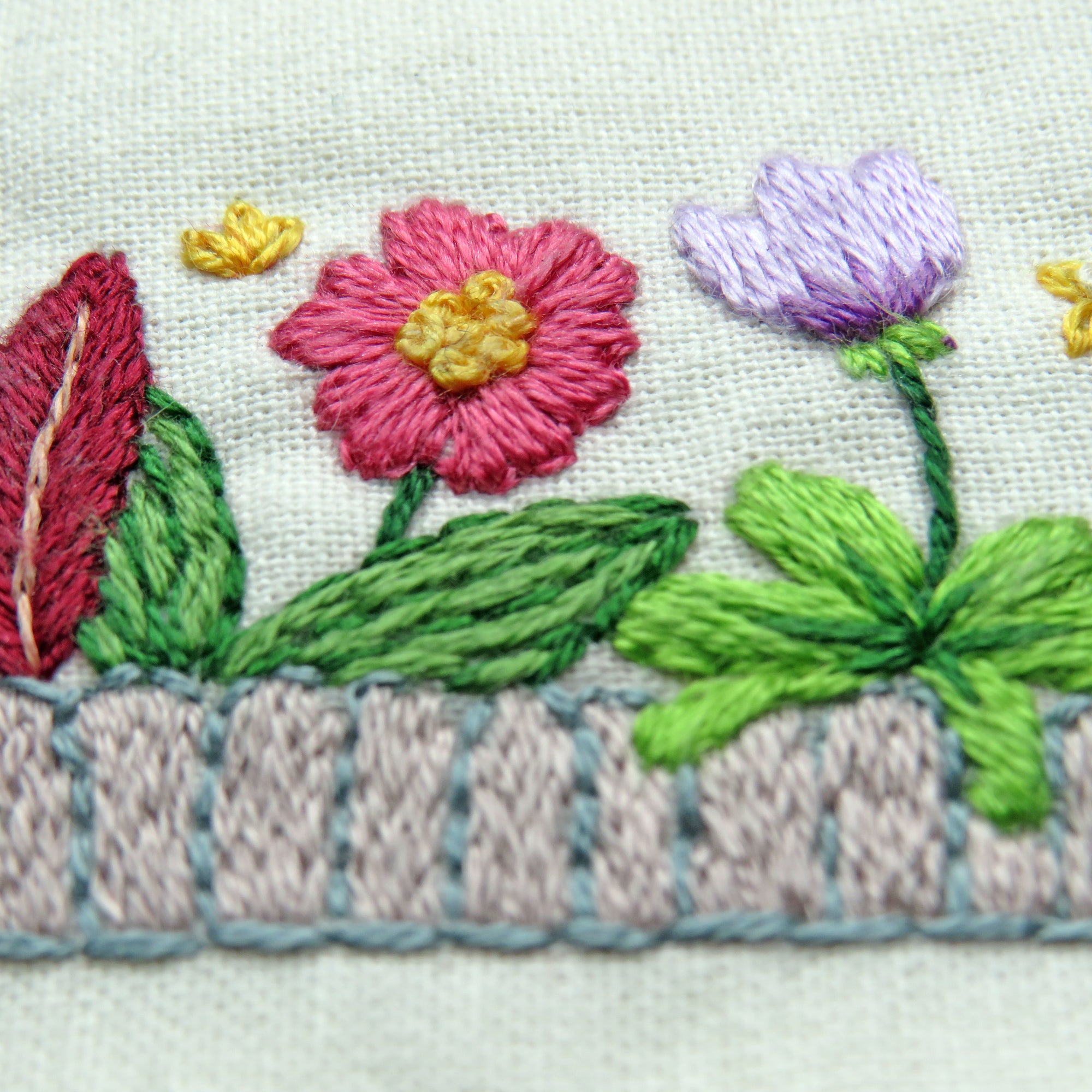 Embroidered design of flowers and leaves on fabric