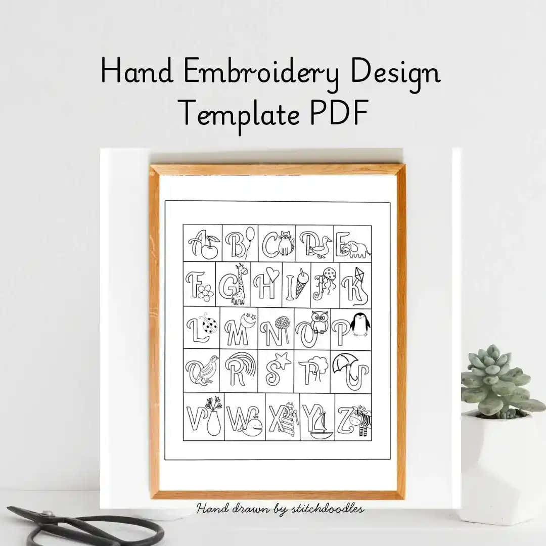 Hand embroidery design template PDF with alphabet and symbols in a wooden frame on a white background.