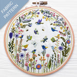Embroidery hoop with floral and bird pattern on a white background