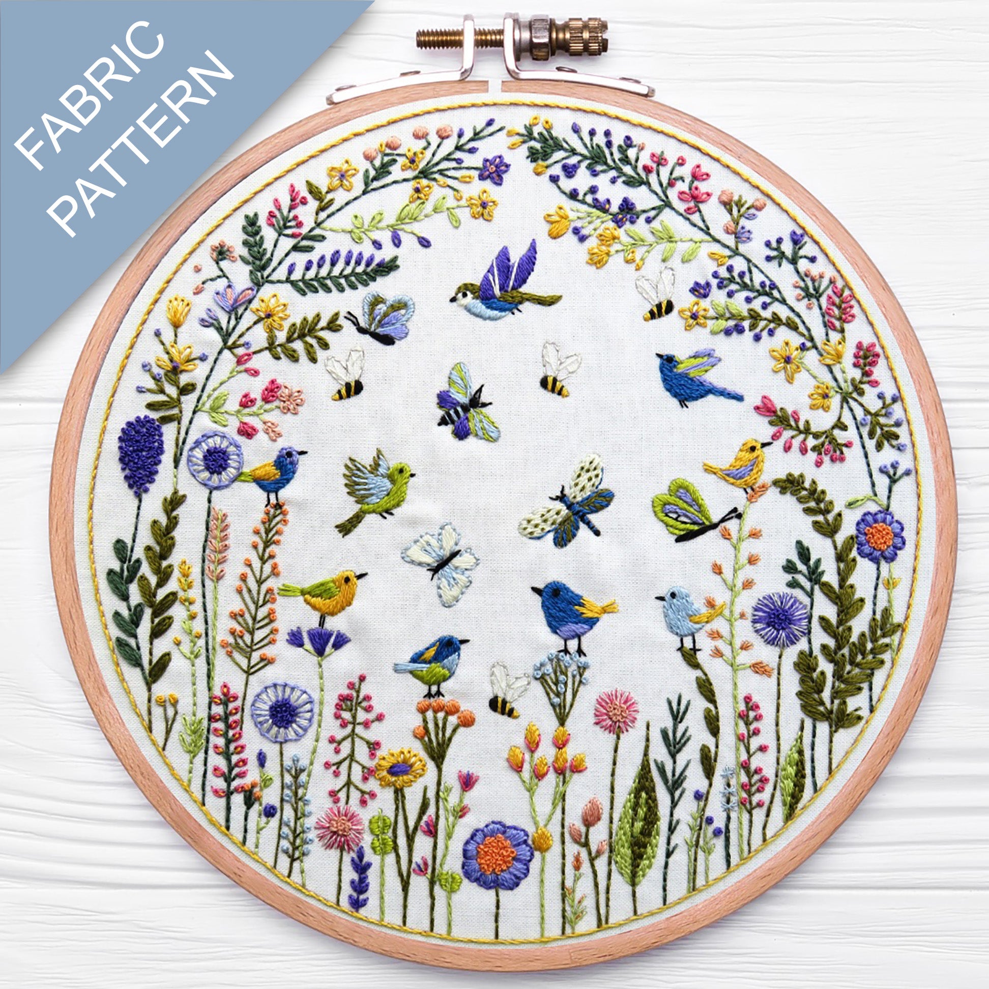 Embroidery hoop with floral and bird pattern on a white background