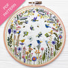 Embroidery hoop with floral and bird design on a white background