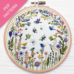 Embroidery hoop with floral and bird design on a white background