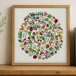 Framed artwork with a colorful circular design of animals and plants on a wooden shelf.