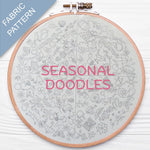 Embroidery hoop with 'Seasonal Doodles' fabric pattern on a white background