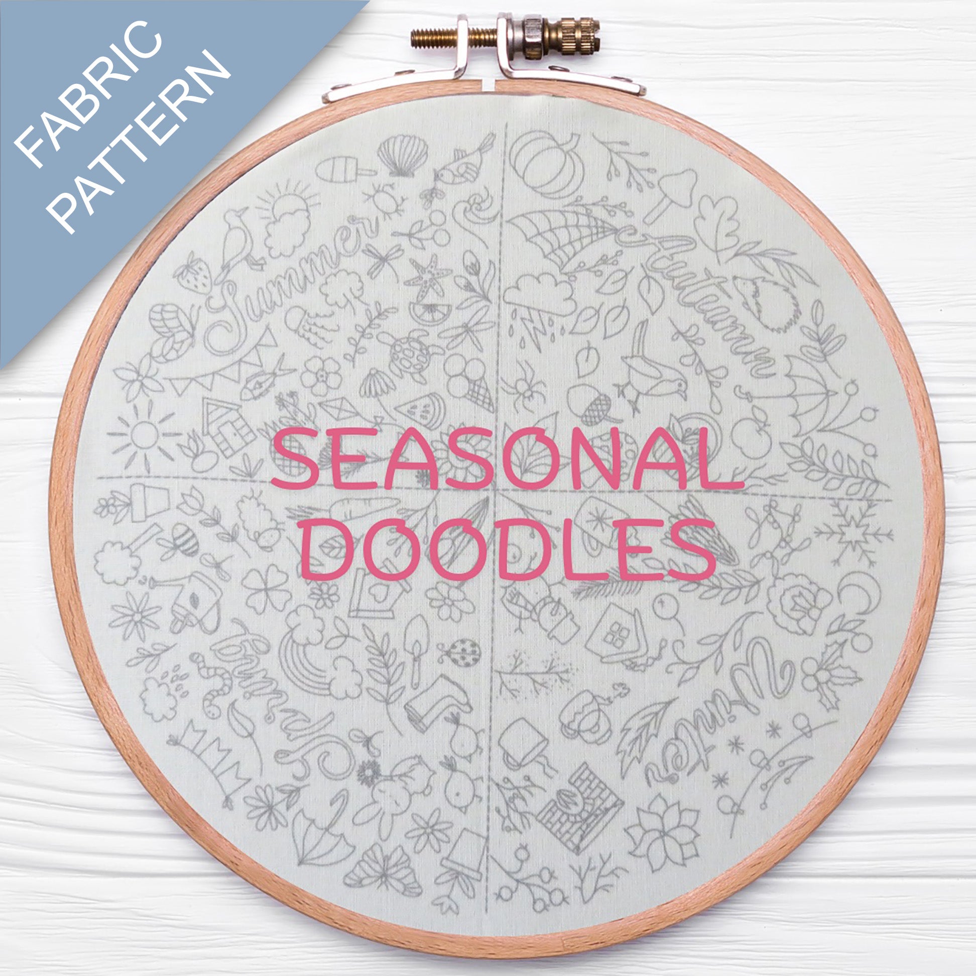 Embroidery hoop with 'Seasonal Doodles' fabric pattern on a white background
