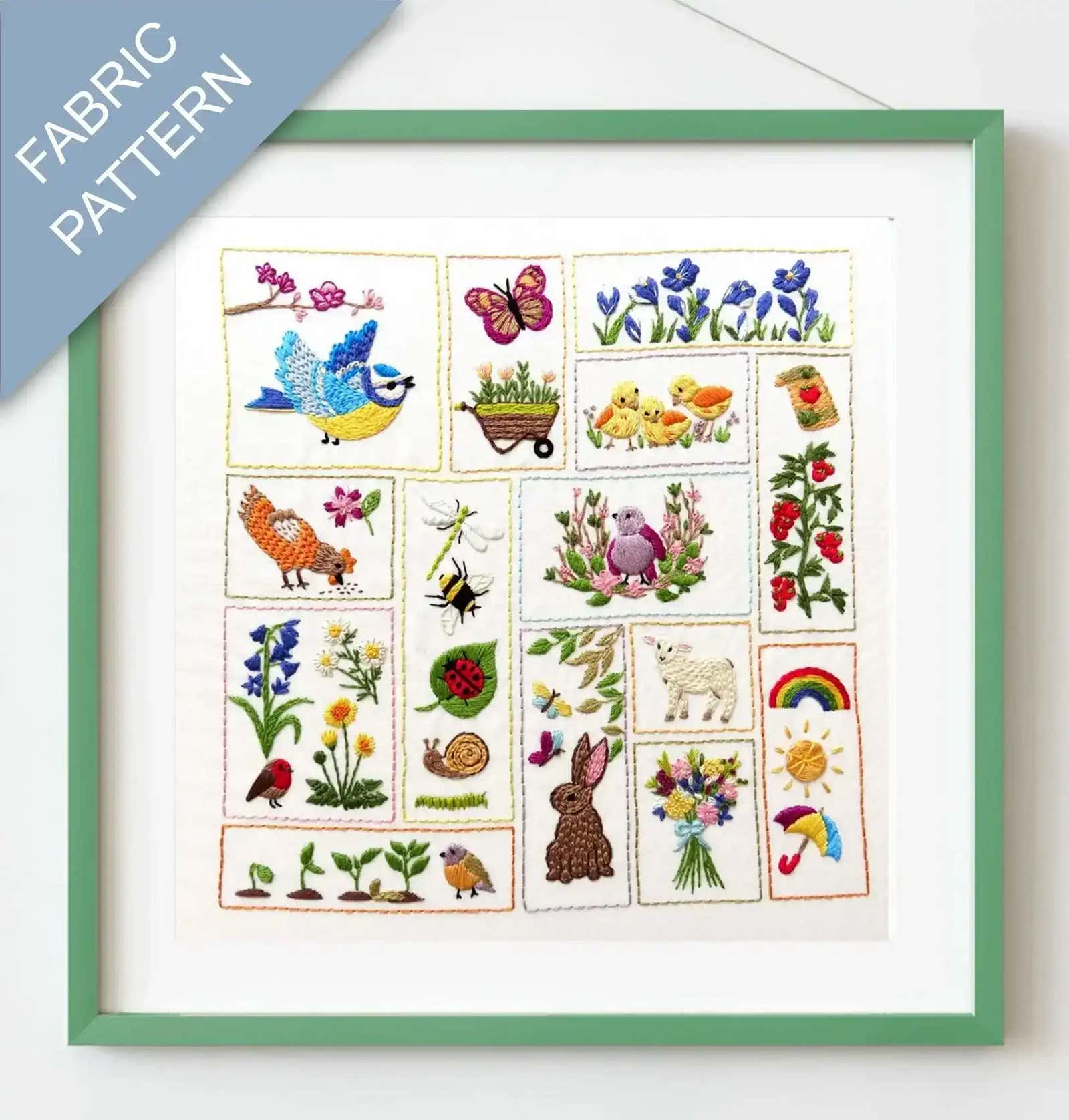 Framed fabric pattern with embroidered designs of animals, plants, and nature-themed elements.