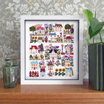 Framed artwork with colorful houses and plants on a wooden surface with decorative wallpaper.