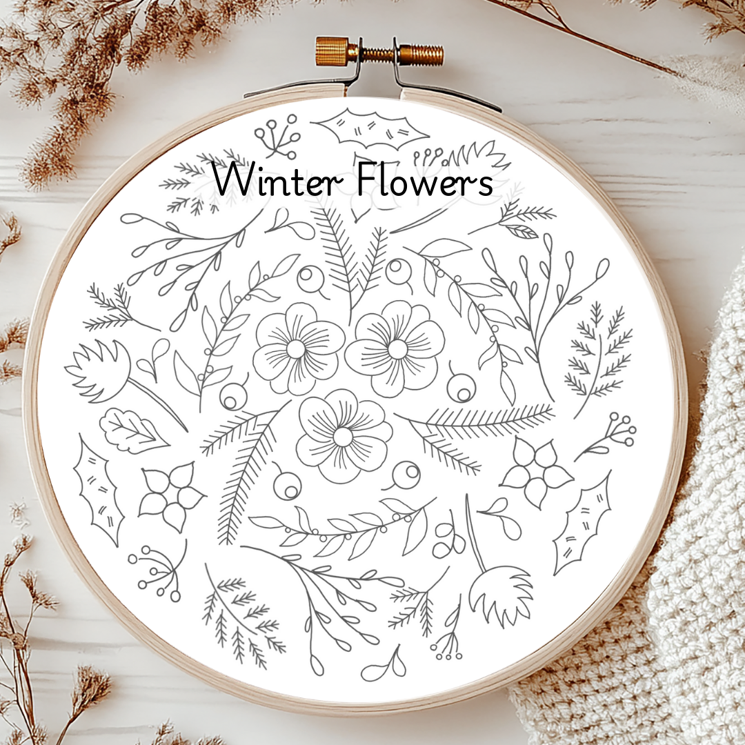 Embroidery hoop with 'Winter Flowers' design on a wooden surface.