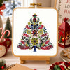 Decorative Christmas scene with a colorful tree design on a stand, surrounded by festive items.