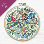 Embroidery hoop with colorful floral and bird design on a white background