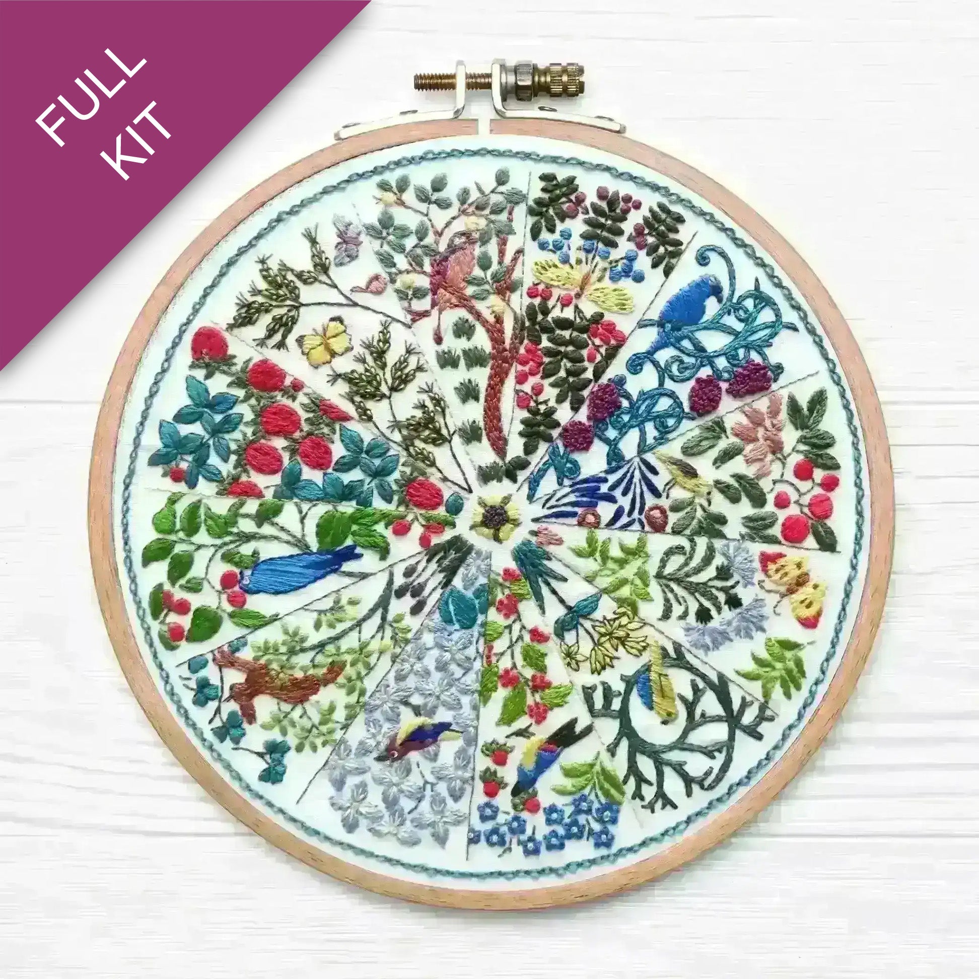 Embroidery hoop with colorful floral and bird design on a white background